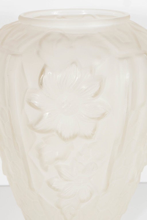 Thus stunning relief frosted vase features stylized cubist geometric and floral designs. A great accent piece that would make a unstated elegant statement.It is signed made in France on the bottom as well. It is in mint condition.