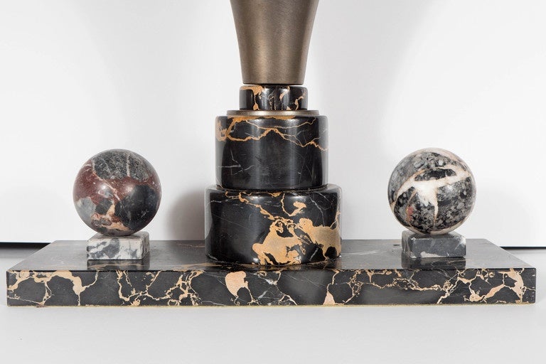 This stunning Art Deco desk lamp features hand carved exotic marble spheres on either side of a antique brass uplight on a stepped skyscraper style base. This is a show stopper piece for a desk. This piece has been newly rewired and in excellent