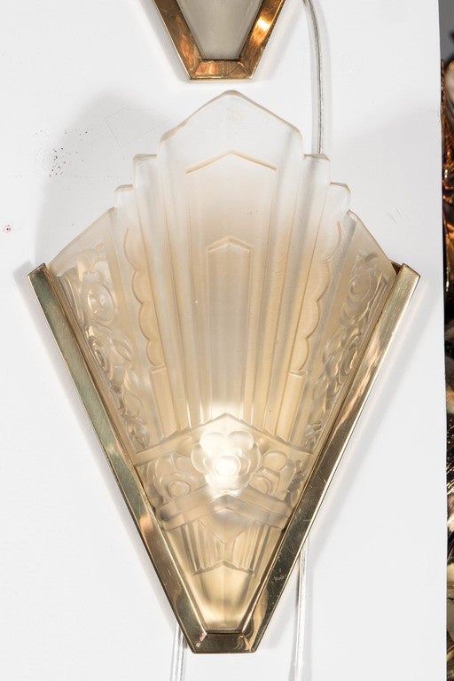 These gorgeous sconces feature a highly stylized Art Deco geometric and floral design in frosted relief glass executed in a cubist manner.They are set in a brass frame and they have been completely rewired. They are signed Degue as well.They can