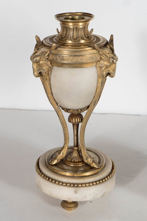 A fine French ormolu-mounted alabaster candlesticks with heavily gilded and three scrolled goat head supports and hoof feet. The alabaster is hand-carved. The decoration is neoclassical with a beaded motif at the base of the candle stands and
