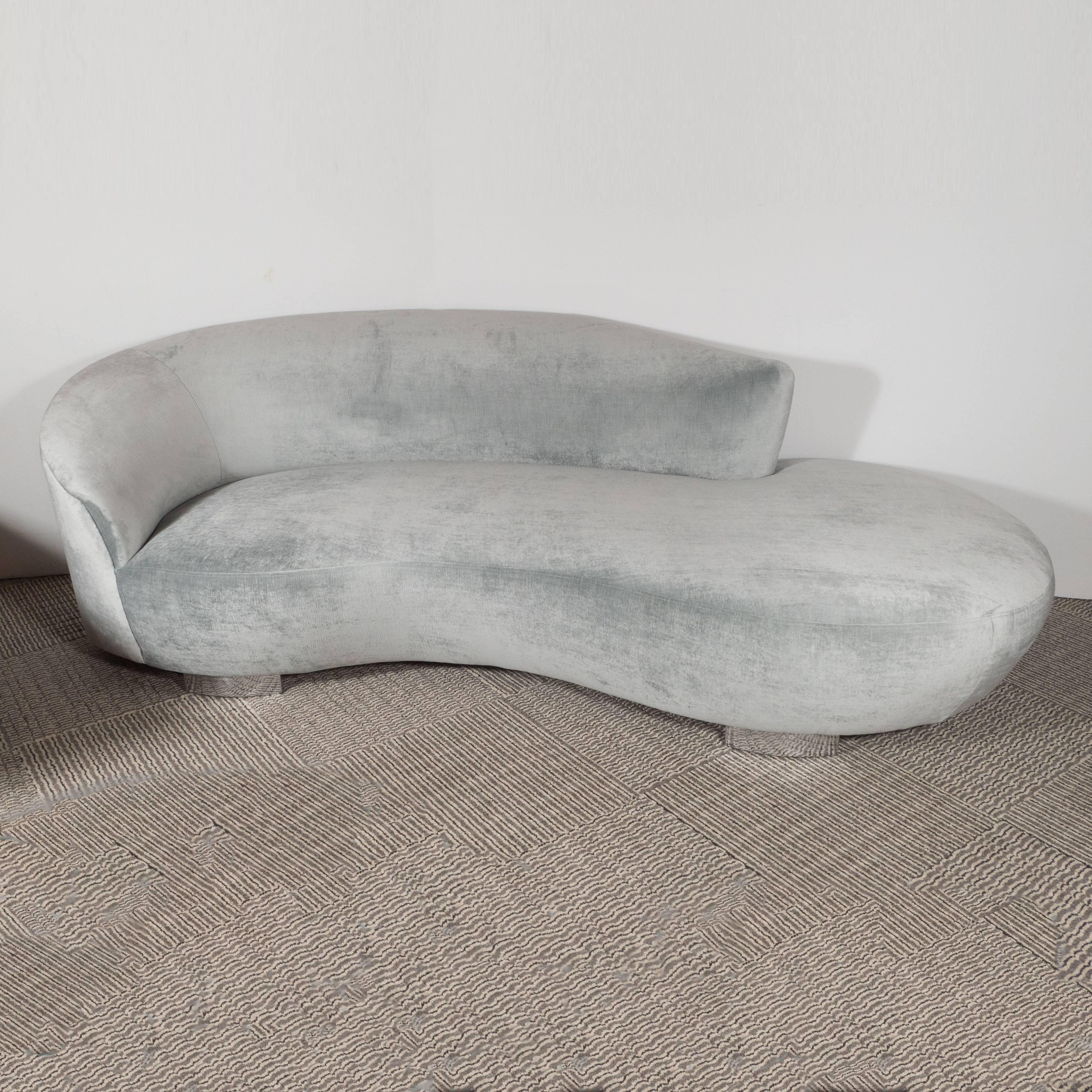 With its sinuous forms and graceful lines, this sofa instantly recalls the timeless designs of Vladimir Kagan- one of the most celebrated names in modern furniture. It has been reupholstered in luxe platinum velvet and features polished and radiant