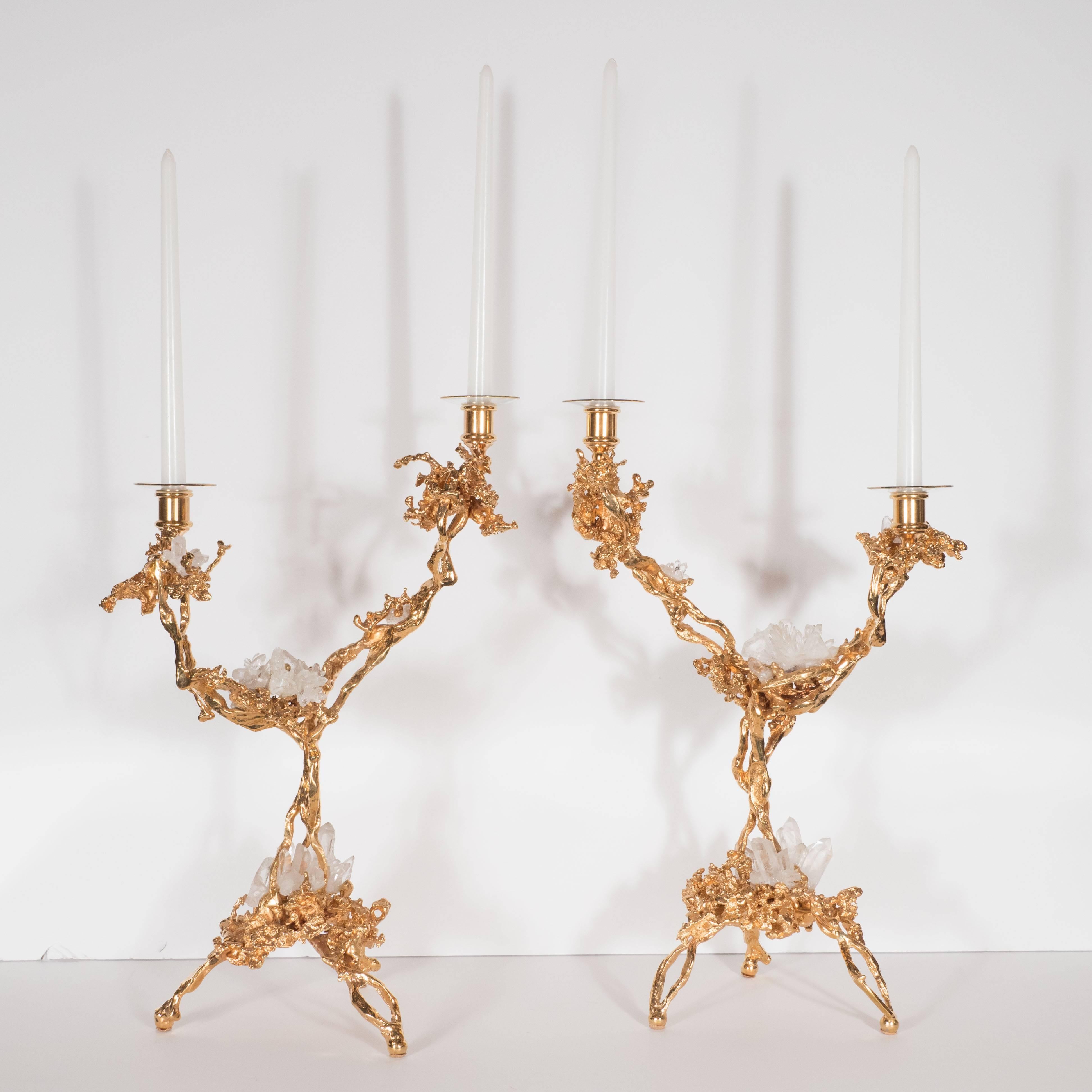 This stunning pair of Mid-Century Modern candlesticks were realized in France, circa 1970 by the esteemed artisan Claude Victor Boeltz. They offer an exploded form sculpted, by hand, and cast in bronze, consisting of two arms and three feet plated