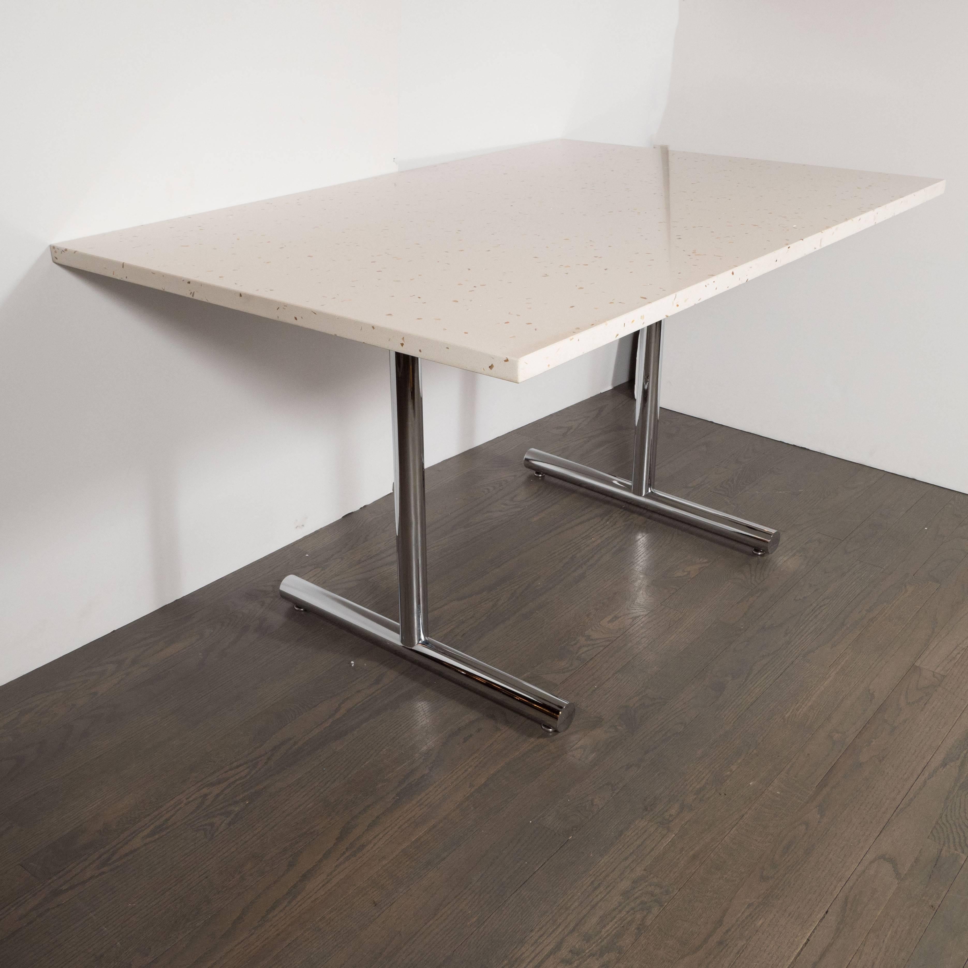 This bold and beautiful Mid-Century Modern table features a rectangular top executed in Terrazzo, offering a wealth of texture, as well as hues of mother-of-pearl, caramel and smoked topaz. The table is supported by two tubular legs that culminate