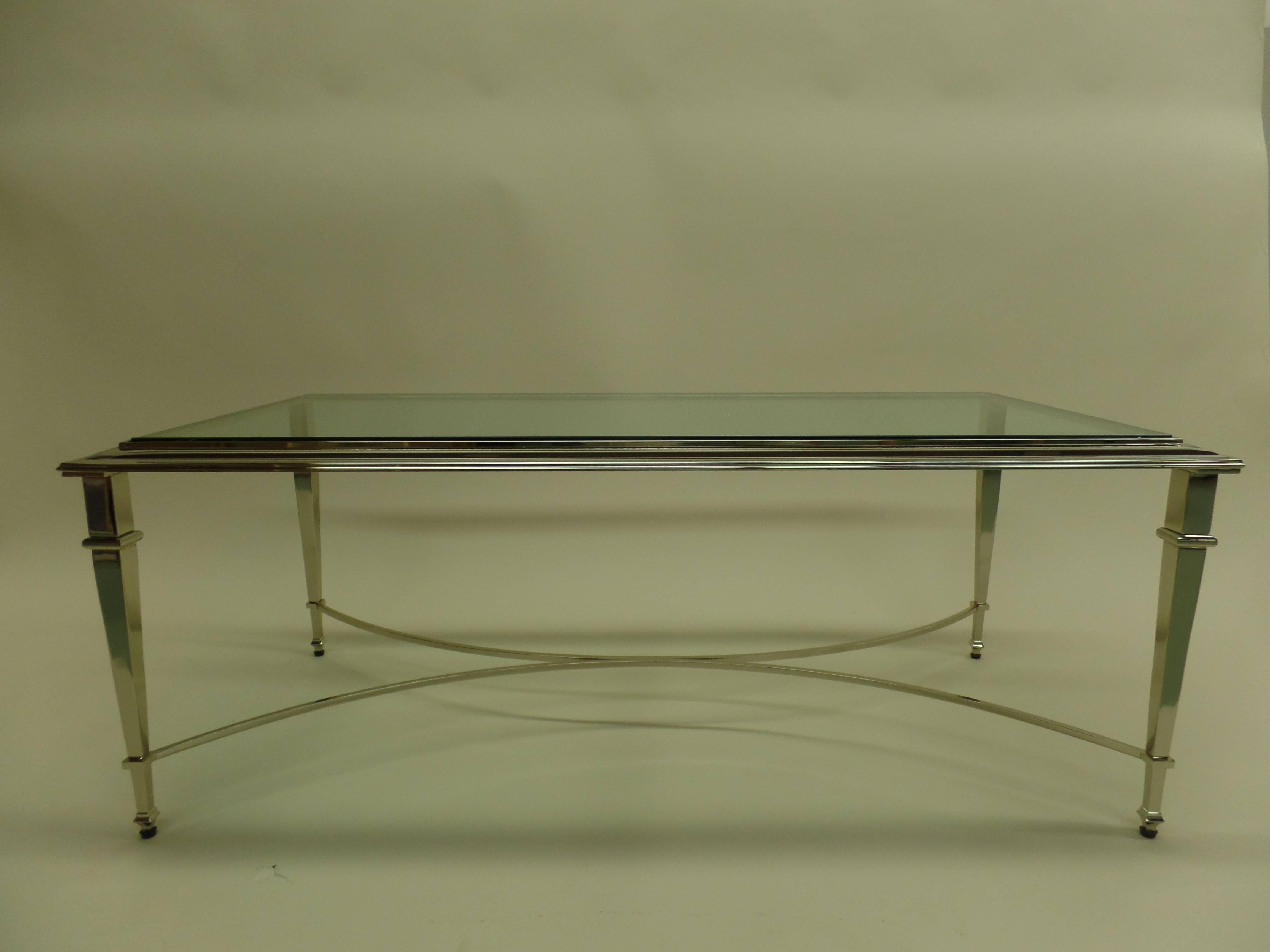 Elegant, timeless French Mid-Century Modern style cocktail table in the neoclassical spirit of Maison Ramsay.

The piece is delicately nickeled with stunning, tapered legs united by an X-frame stretcher. The top is raised, characteristic of Ramsay