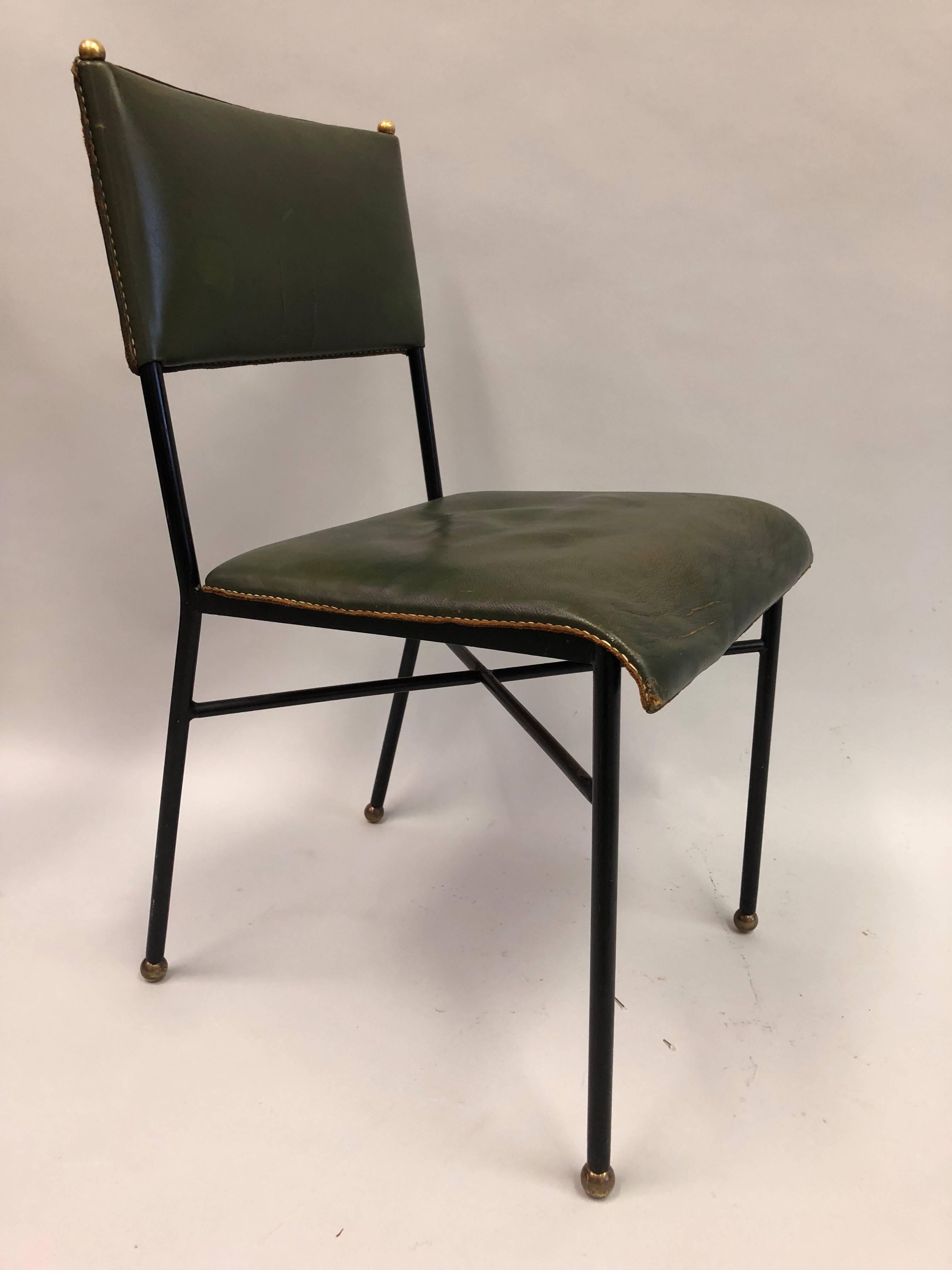Elegant French Mid-Century Modern hand-stitched leather desk chair by Jacques Adnet.

Enameled steel frame with neoclassical X-frame stretcher and rear saber legs; the feet and details ending in round solid brass sabots and the seat and back