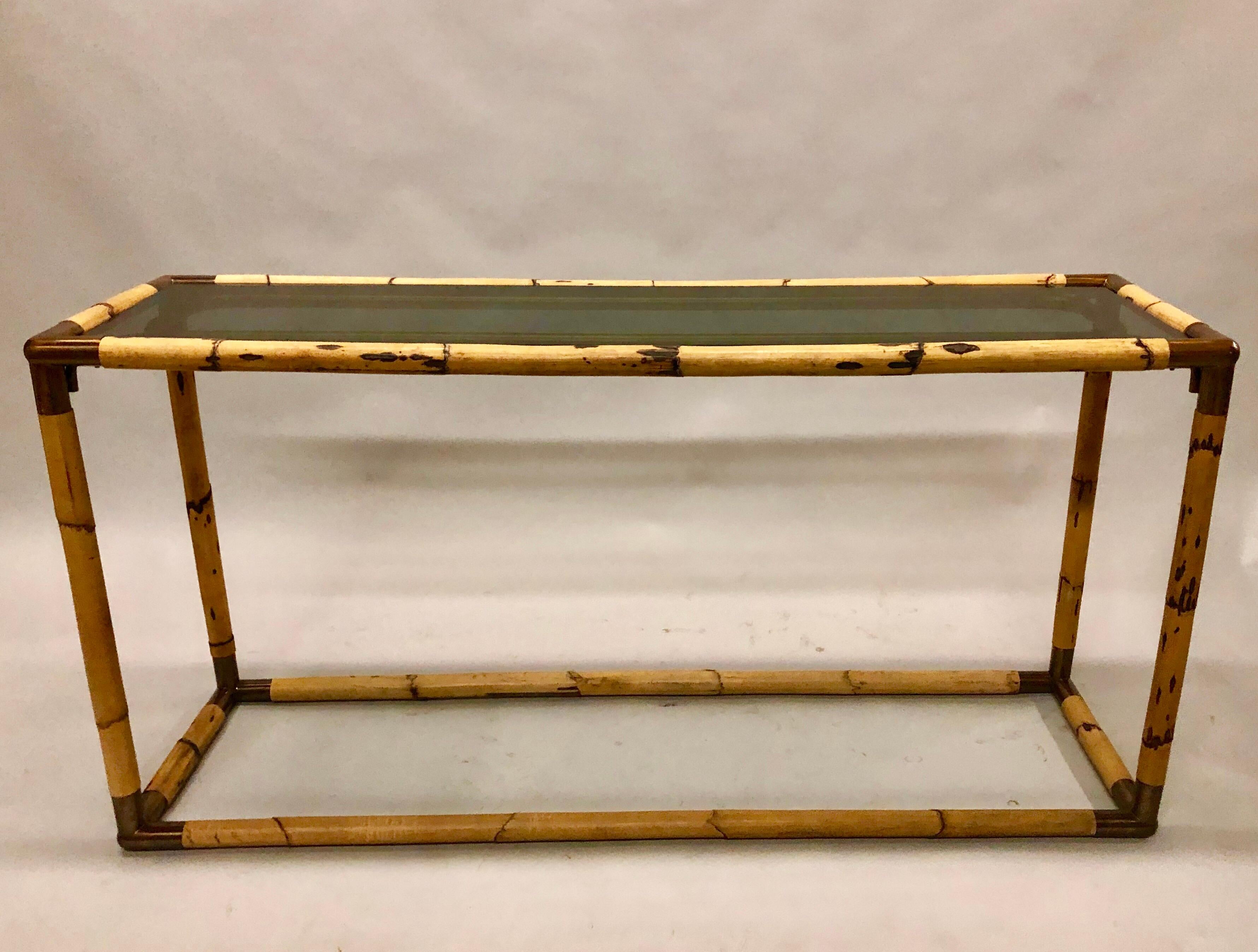 An elegant Italian Mid-Century Modern bamboo / rattan and smoked glass console or sofa table by Giovanni Banci circa 1970. Original smoked glass top accompanies the piece.

Giovanni Banci was a Florentine sculptor and furniture designer. His