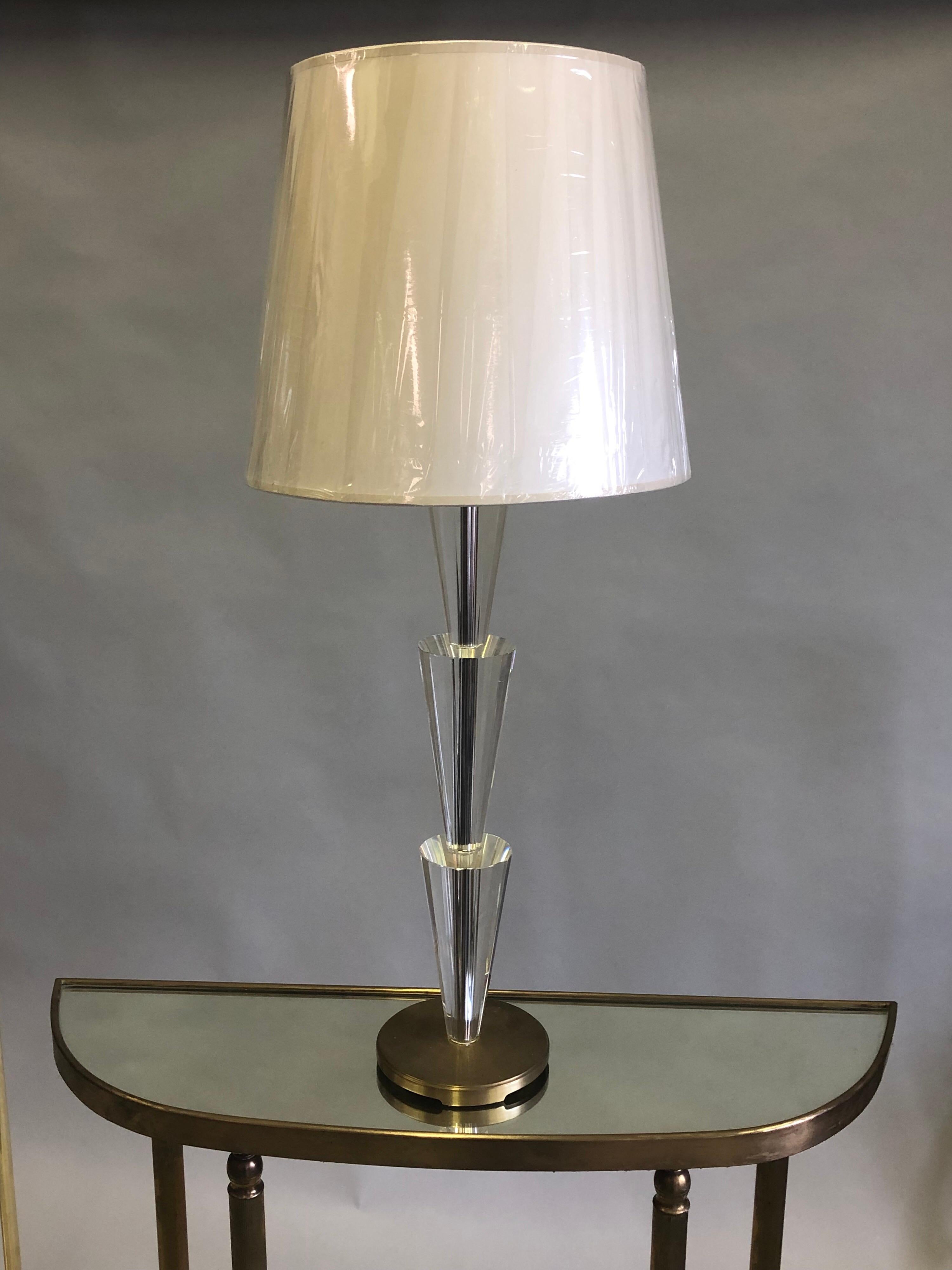 Sober and elegant pair of solid crystal table lamps reflecting modern and neoclassical sensibilities with each piece of crystal tapered and delicately cut to reflect light. Each pyramidal form is arranged sequentially on top of each other and rests