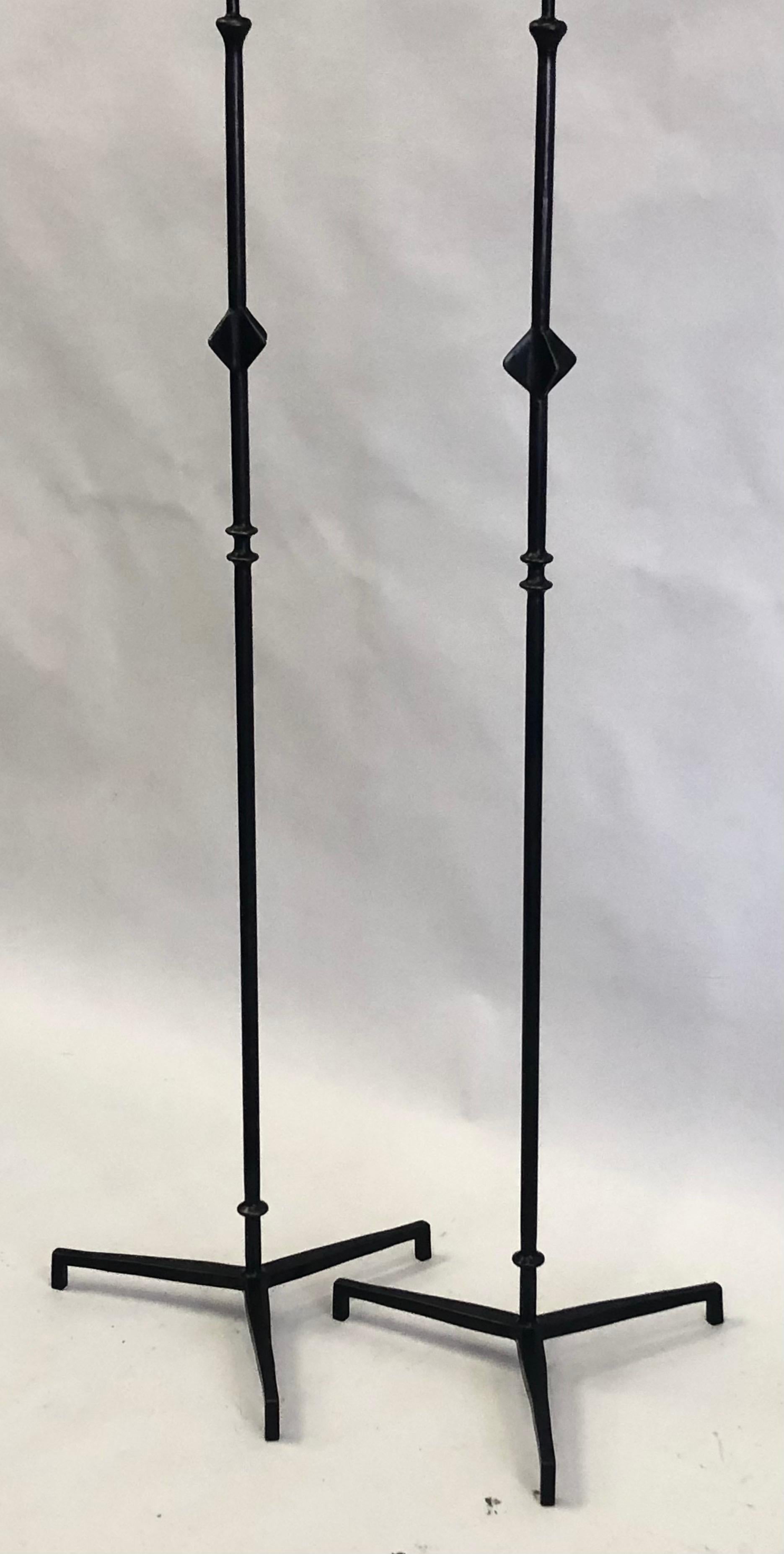 A timeless pair of French forged iron floor lamps with dark patina decorated with the form of a star, after Alberto & Diego Giacometti for Jean-Michel Frank. Model: Etoile. Dimensions: H: 72 x D 19.5 ; Shades are for demonstration only.

The
