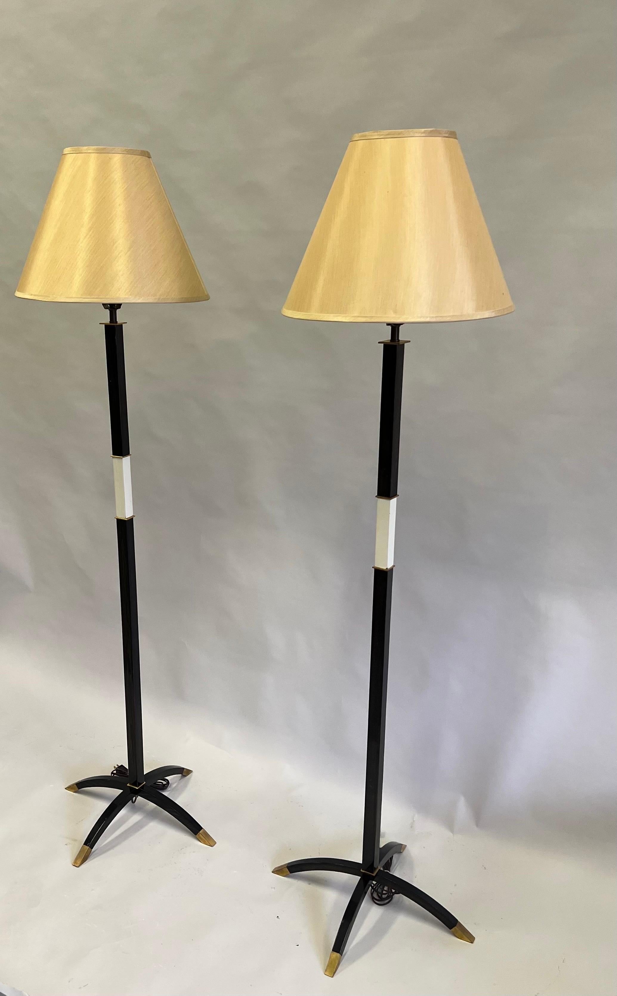 Important, Elegant pair of French late Art Deco Floor lamps by Dominique in lacquered wood with brass sabots and detailing. Shades are for demonstration purposes only. Height of base alone without shade is 54