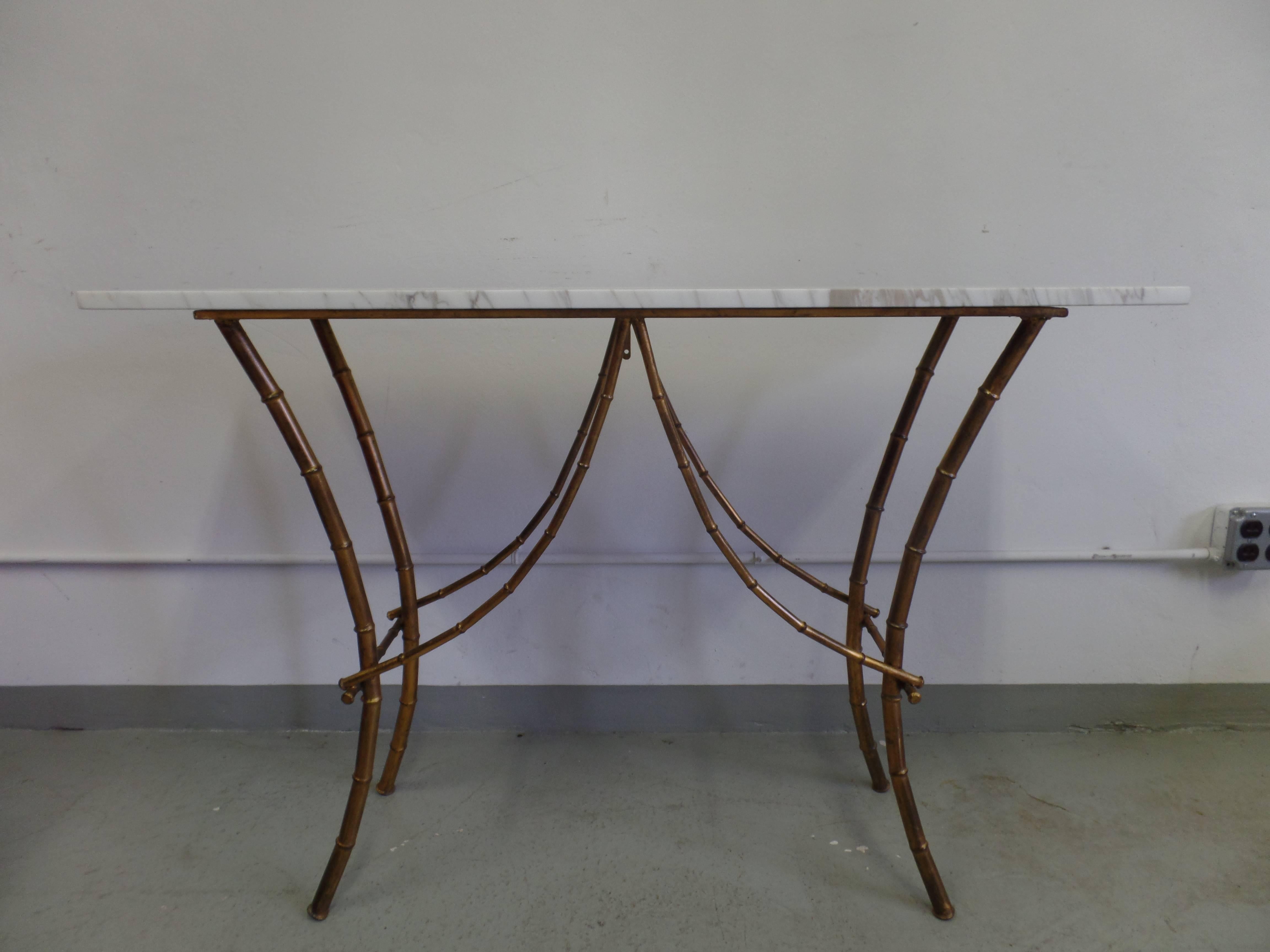 Elegant French Mid-Century console or sofa table by Maison Baguès in the modern neoclassical taste. The table is composed of faux bamboo gilt iron with a patina of gold and bronze shades. It is shown with a delicate marble top of Calacatta crema.