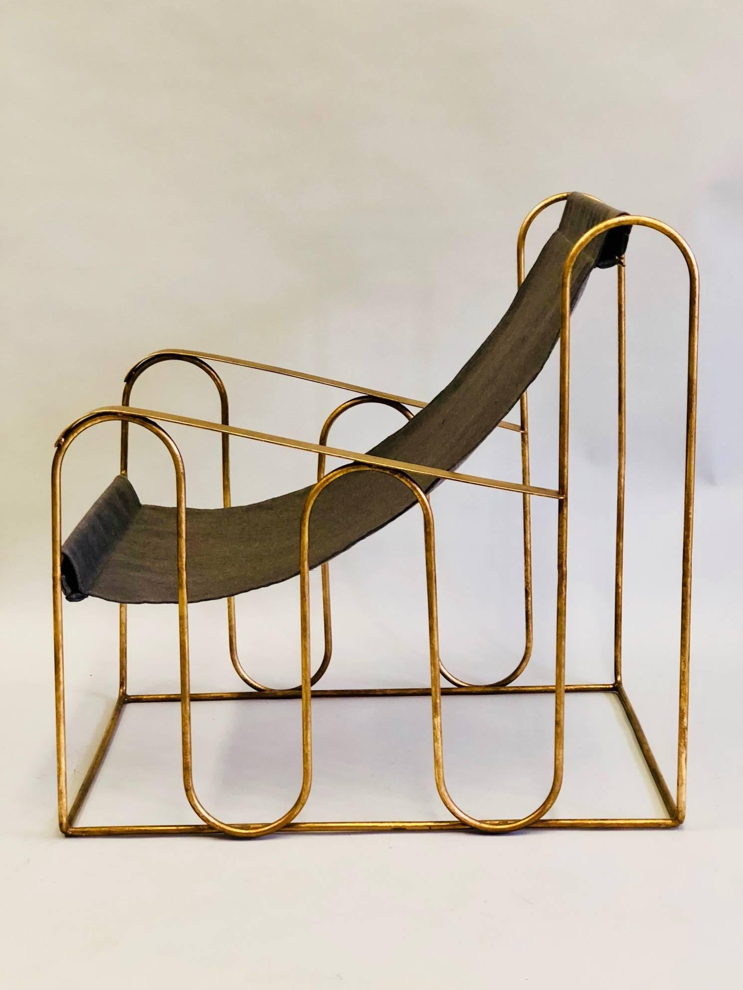 Elegant pair of French Mid-Century hand wrought iron armchairs or club chairs attributed to Jean Royere with a delicate undulating organic lines and a dramatic, open, modern, transparent sensibility. The chairs have been hand-gilt to a subtle