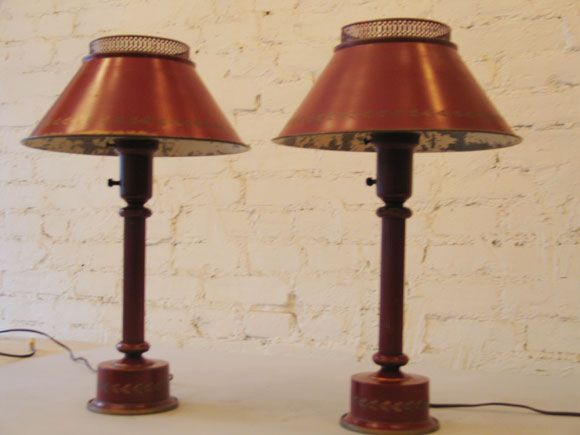 Decorative pair of French midcentury painted tole lamps in a wonderful shade of red with gold leaf decoration near the border of the shade.

Priced and sold individually.