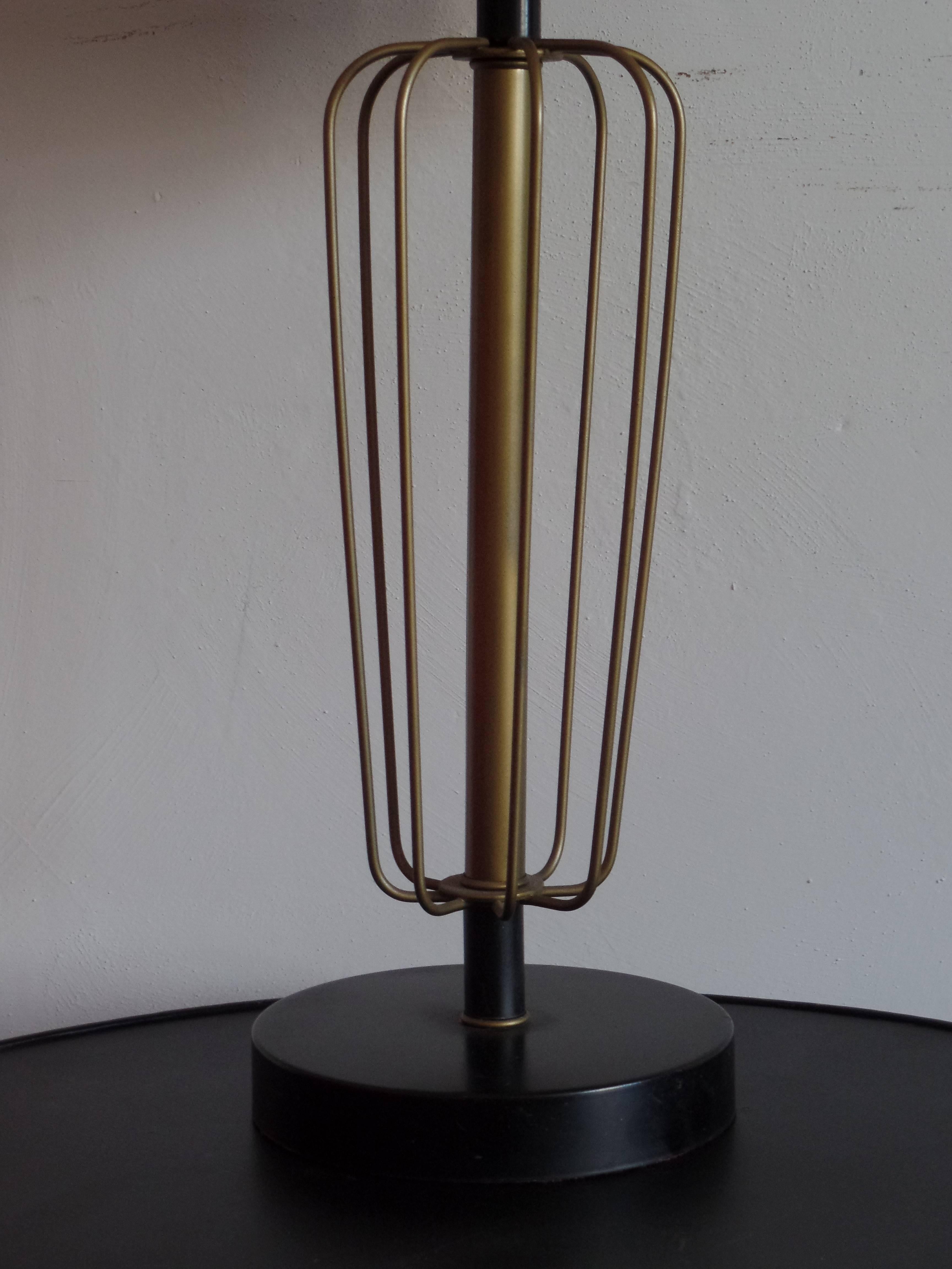 Un'elegante coppia di lampade da tavolo in acciaio smaltato che parla della nuova modernità postbellica. I pezzi hanno la forma di sfere oblunghe che enfatizzano le semplici linee parallele, le forme trasparenti e la sobrietà del periodo Mid-Century