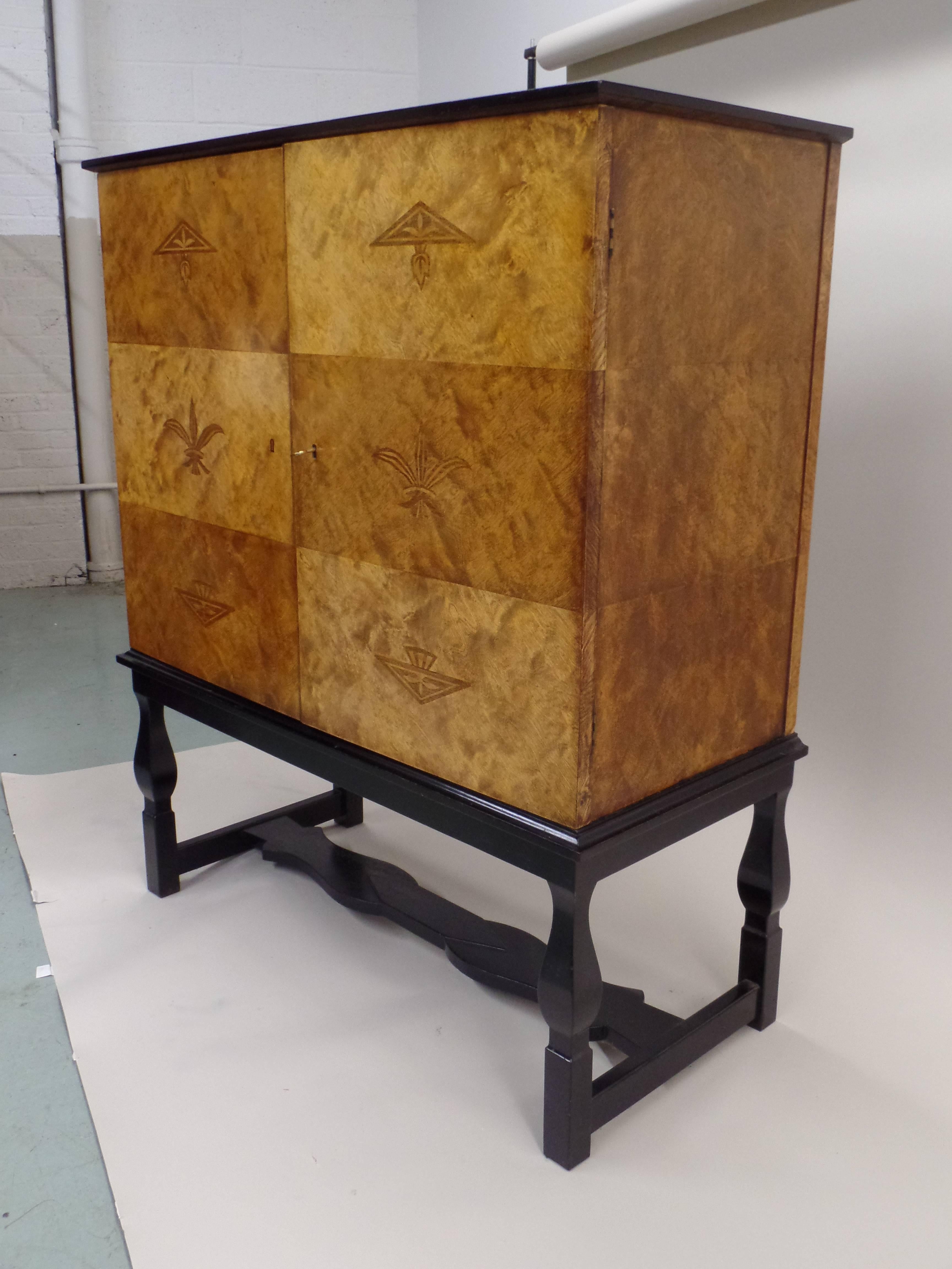 An Important 'Swedish Grace' / Swedish Art Deco / Modern Neoclassical cabinet, sideboard, buffet, bar, storage unit named 'Haga' by Carl Malmsten. The cabinet sits on an ebonized base and it has inlays of geometric decoration and stylized plant