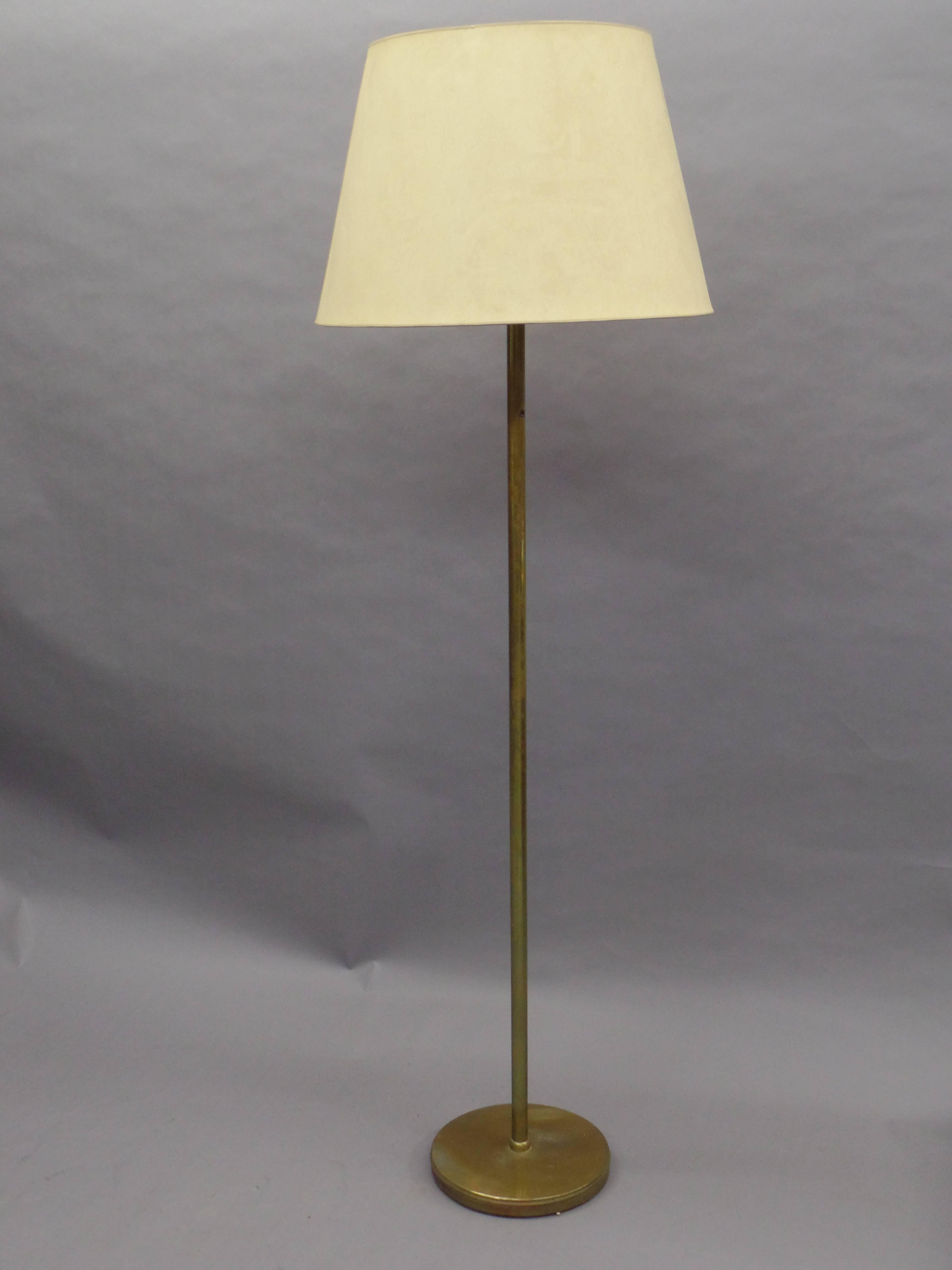 Large, elegant, sober pair of French Mid-Century Modern solid brass standing lamps with pure, modern lines and delicately fluted. 

Shades are for demonstration purposes only.

References: Maison Jansen, Ramsay

 