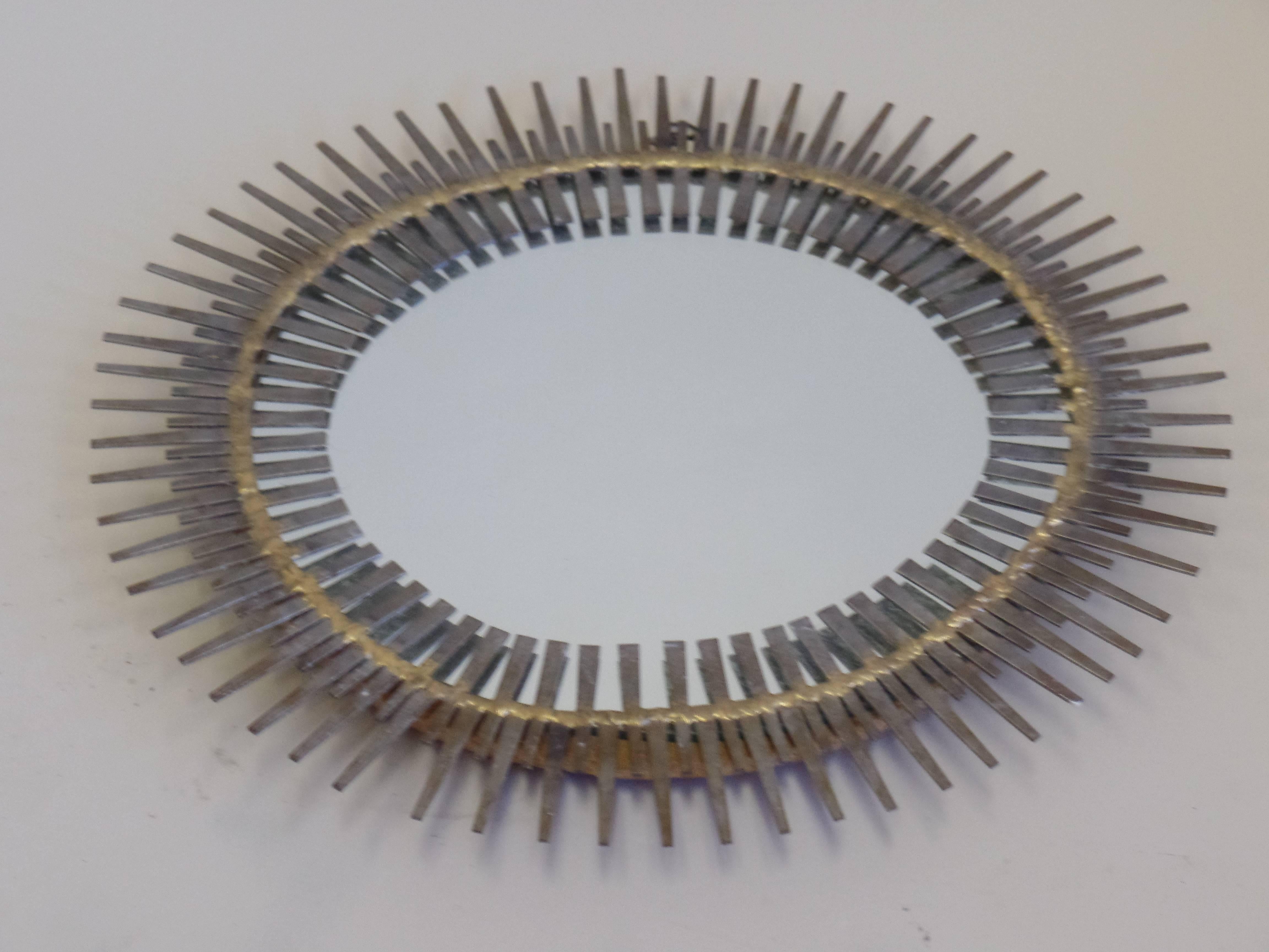 Handmade Mid-Century Modern French Canadian mirror in the form of sunburst by Bela. 

Composed of flattened iron nail heads soldered together with brass to form a delicate modern Primitive composition. 

 