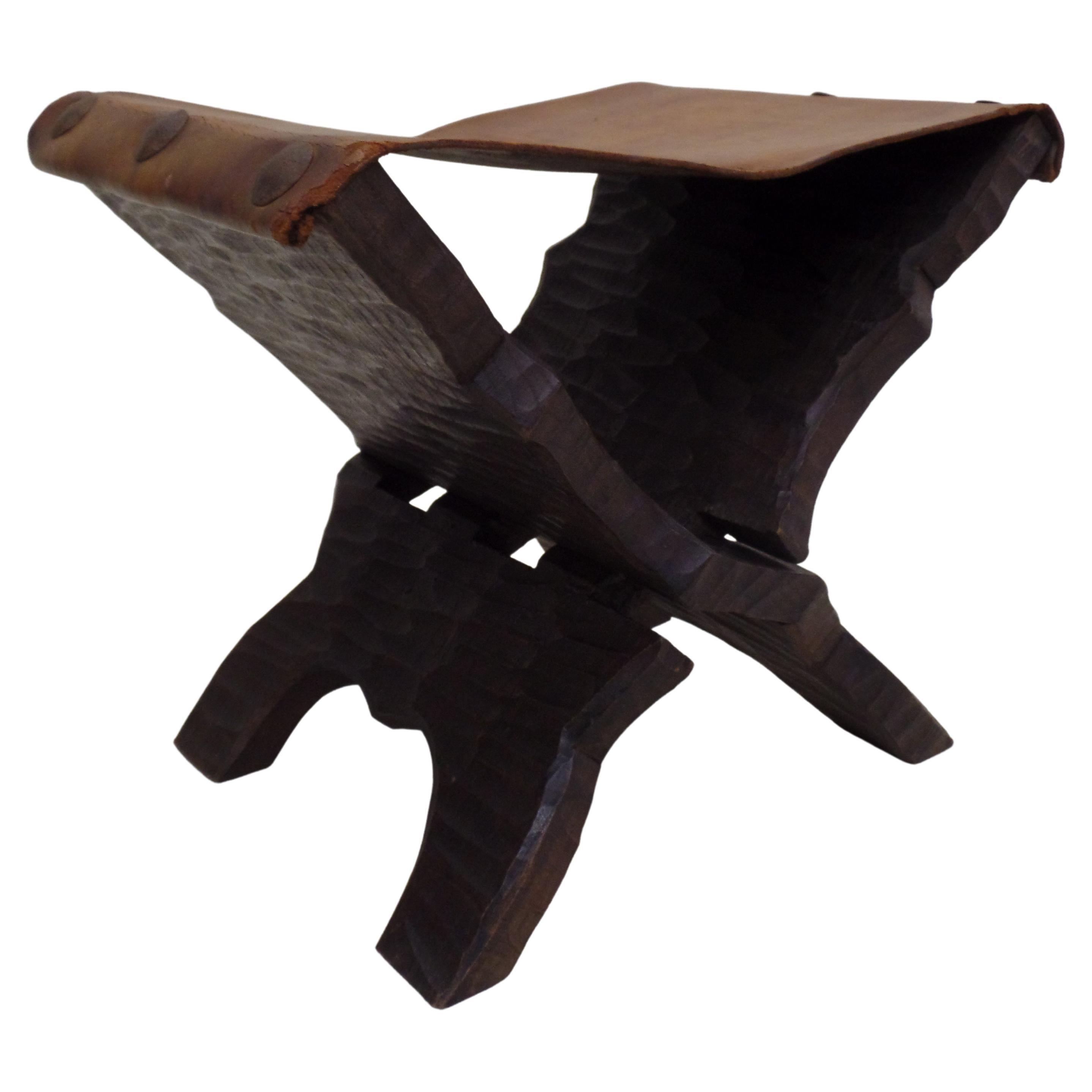 Unique pair of French mid-century hand-carved stools or benches in the style of Jean Michel Frank. 

The pieces feature dramatic hand chiseled wood with natural deep channeling that shows the rough character of the wood. The structure forms a X with