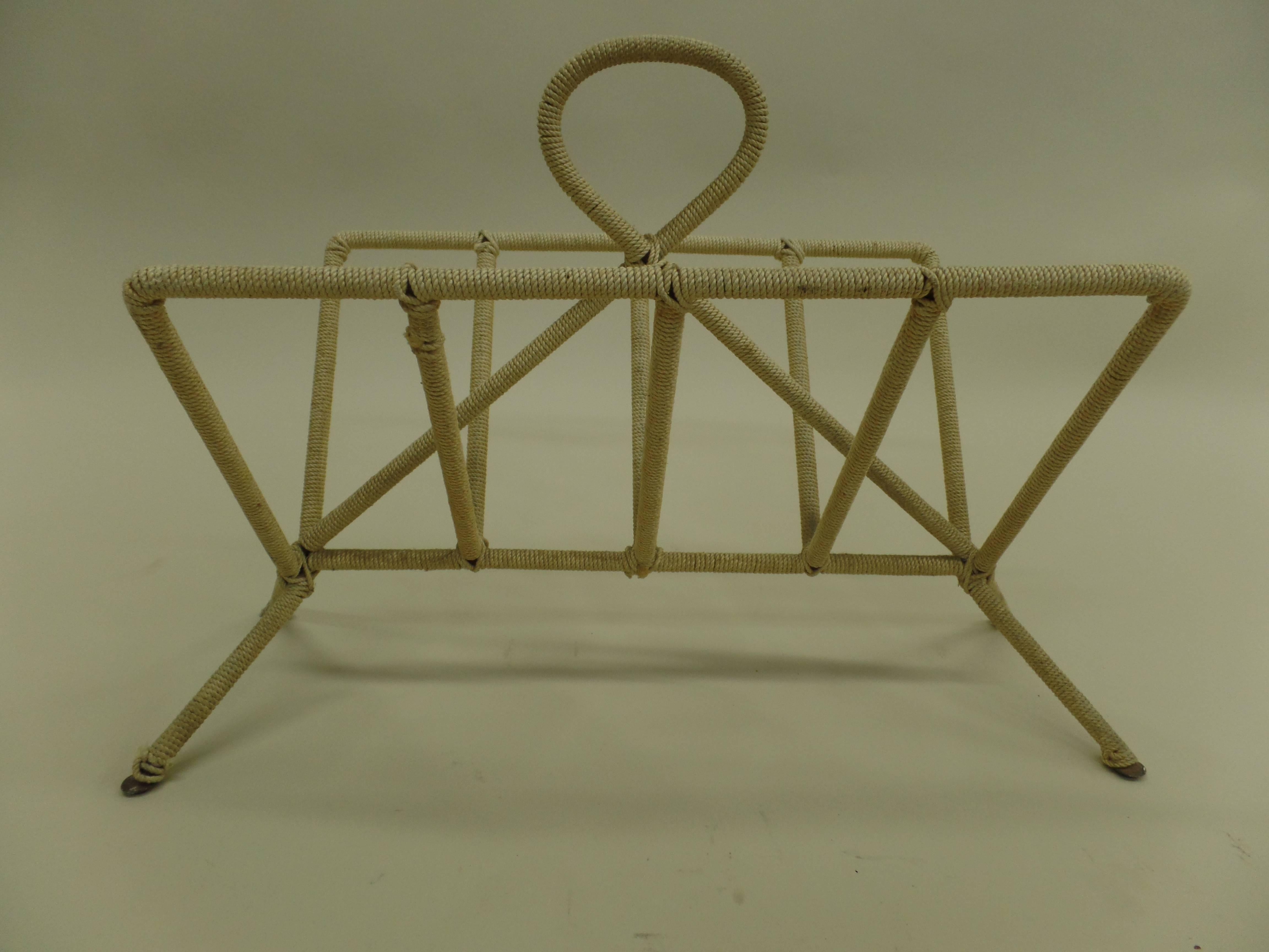 Elegant French Mid-Century Modern magazine rack in the style of Jean Royère.

A piece in the style of Royère in a lyrical poetic form composed of handwrought iron and delicately covered in a thin tightly woven rope.

Literature: Jean Royère,