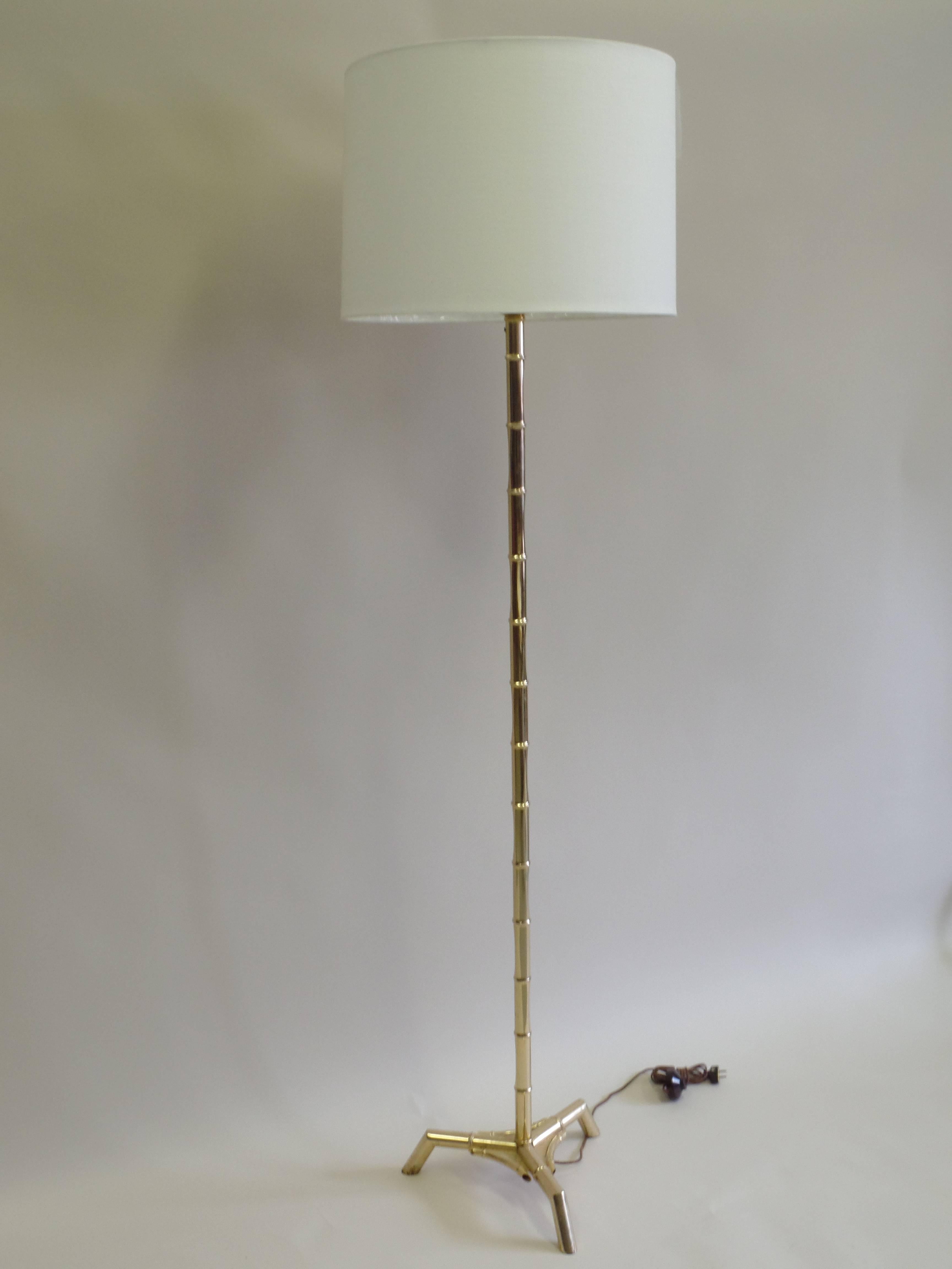Pair of Elegant French Mid-Century brass faux bamboo floor lamps in the Modern Neoclassical spirit resting on a tripod base by Maison Bagues. 

The height shown is 75