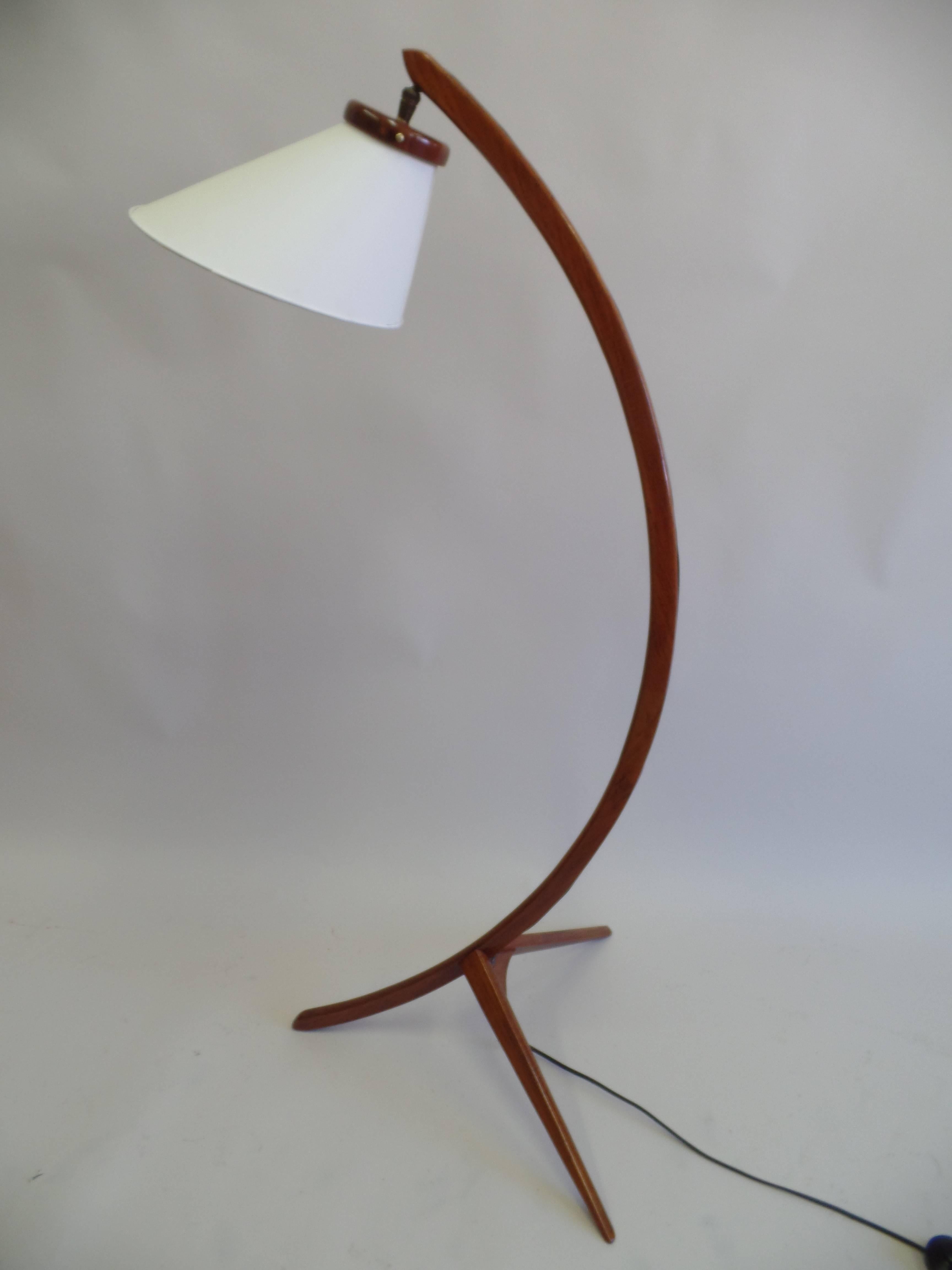 Elegant and stunning pair of Mid-Century Modern standing lamps in solid teak. The curved stem and angled shade are perfectly balanced over a broad tripod base. The iconic form is emblematic of progressive 1950s design.

Sold as a