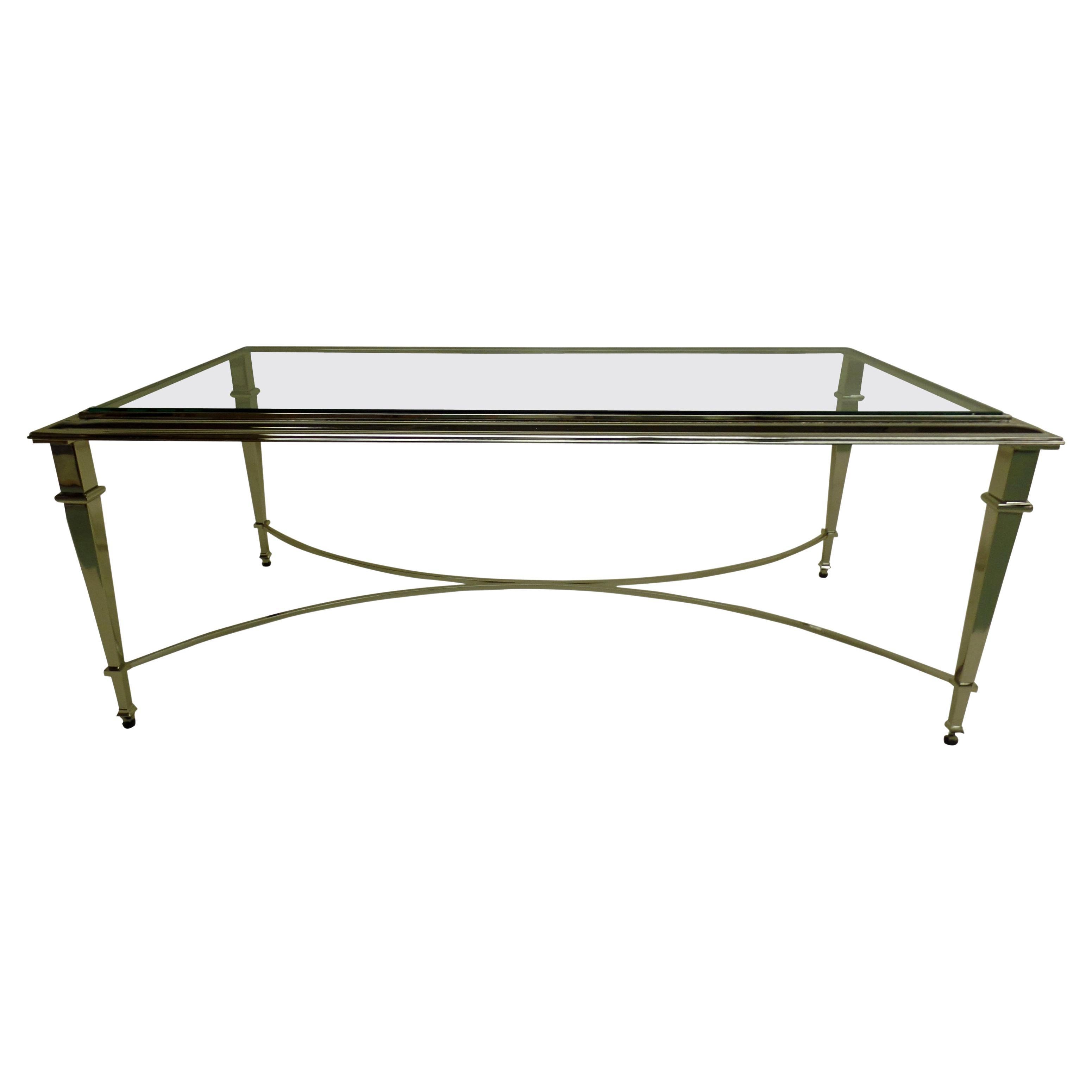 Elegant, timeless French Mid-Century Modern style cocktail table in the Neoclassical spirit of Maison Ramsay. The piece is delicately nickeled with stunning, tapered legs united by an X-frame stretcher. The top is raised, characteristic of Ramsay