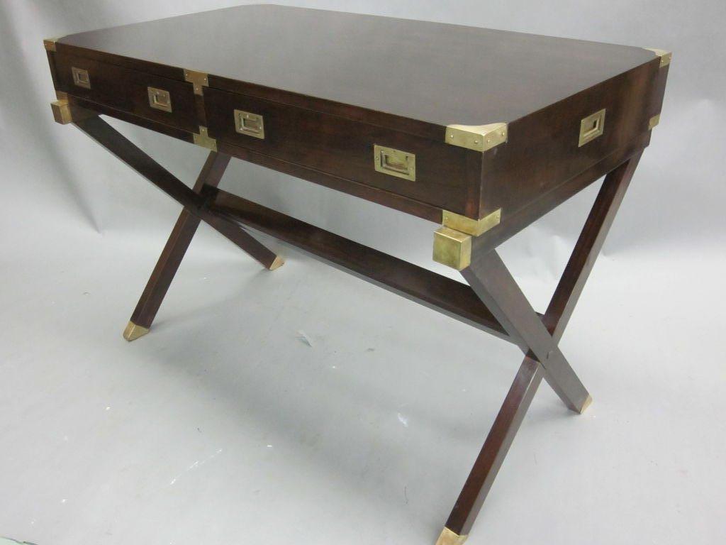 This rare and exquisite French Modern neoclassical Campaign desk or writing table by Maison Jansen is a master work of design and craftsmanship balancing form, function with a subtle color balance of dark mahogany and antiqued brass. It blends a