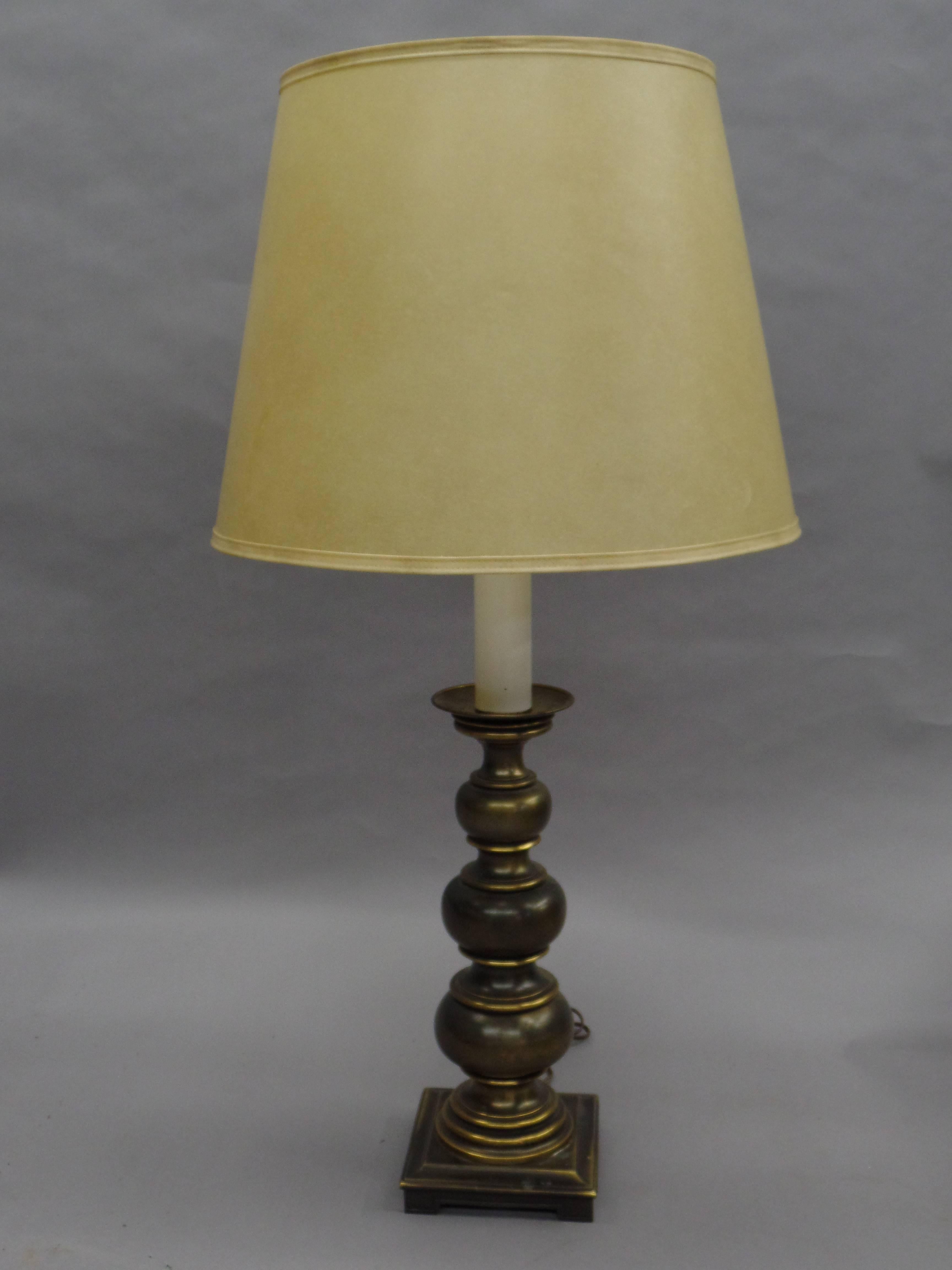 Elegant pair of British Mid-Century brass ball lamps in the modern neoclassical spirit with a graduated series of brass balls resting on a square base.

Total height as shown is 39" and the height of the brass balls alone is 18.75".