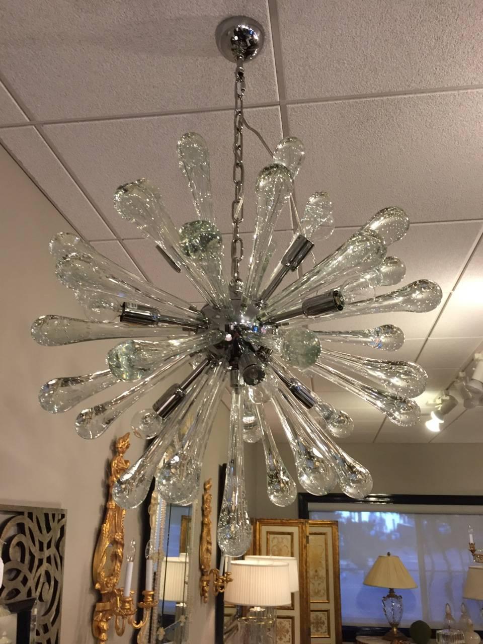 Exquiste pair of handblown, Italian Mid-Century Modern style Venetian glass from Murano in the form of a Sputnik or sunburst. Each arm flares out from a central stem and ends in bulb form. The clear glass itself is clean and delicate with small