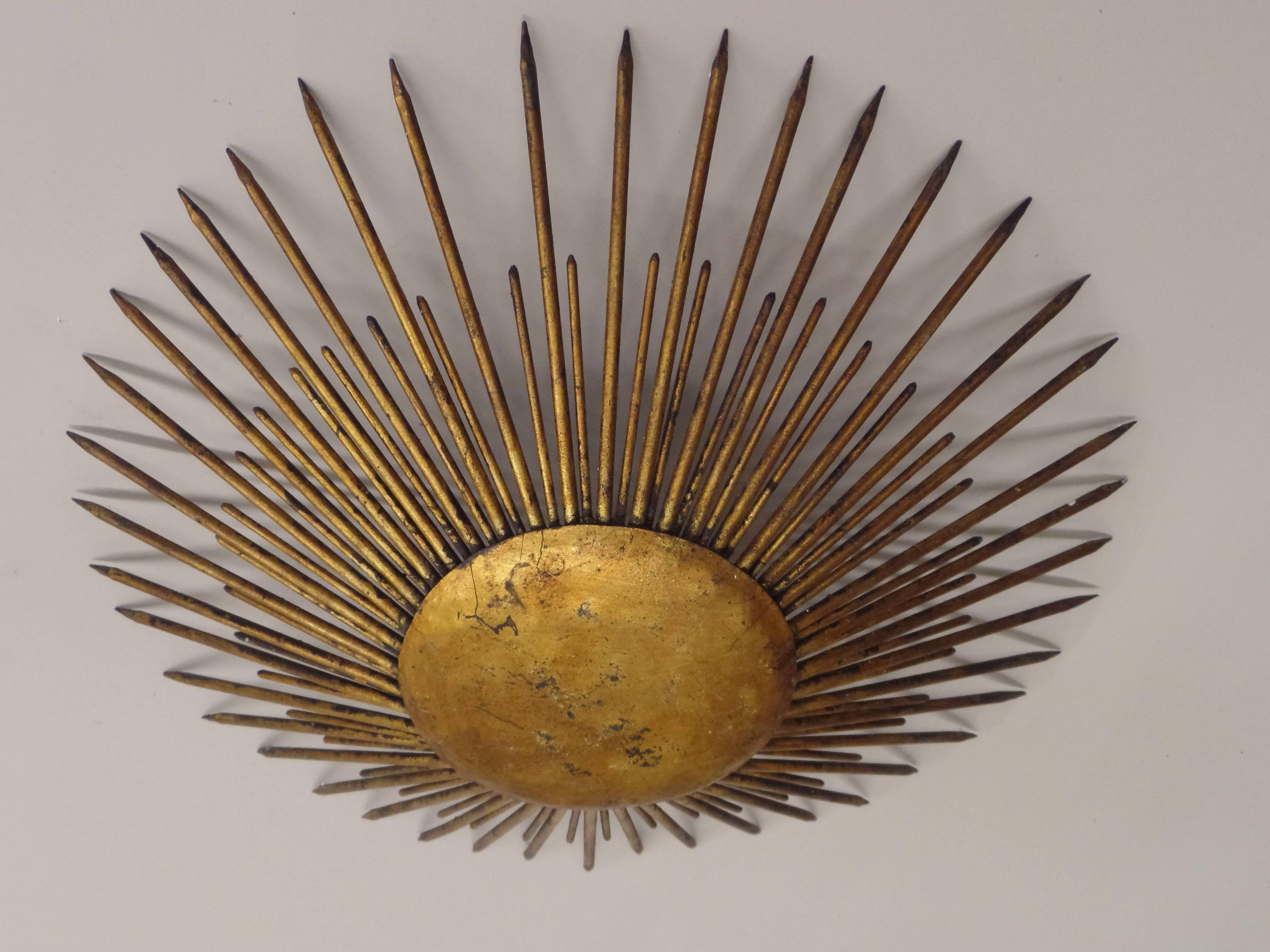 Elegant French gilt wrought iron flush mount fixture or pendant in the Mid-Century Modern Neoclassical spirit with alternating rows tapered spikes emanating from a central curved disc. The piece is  well designed as a pure, balanced, symmetrical