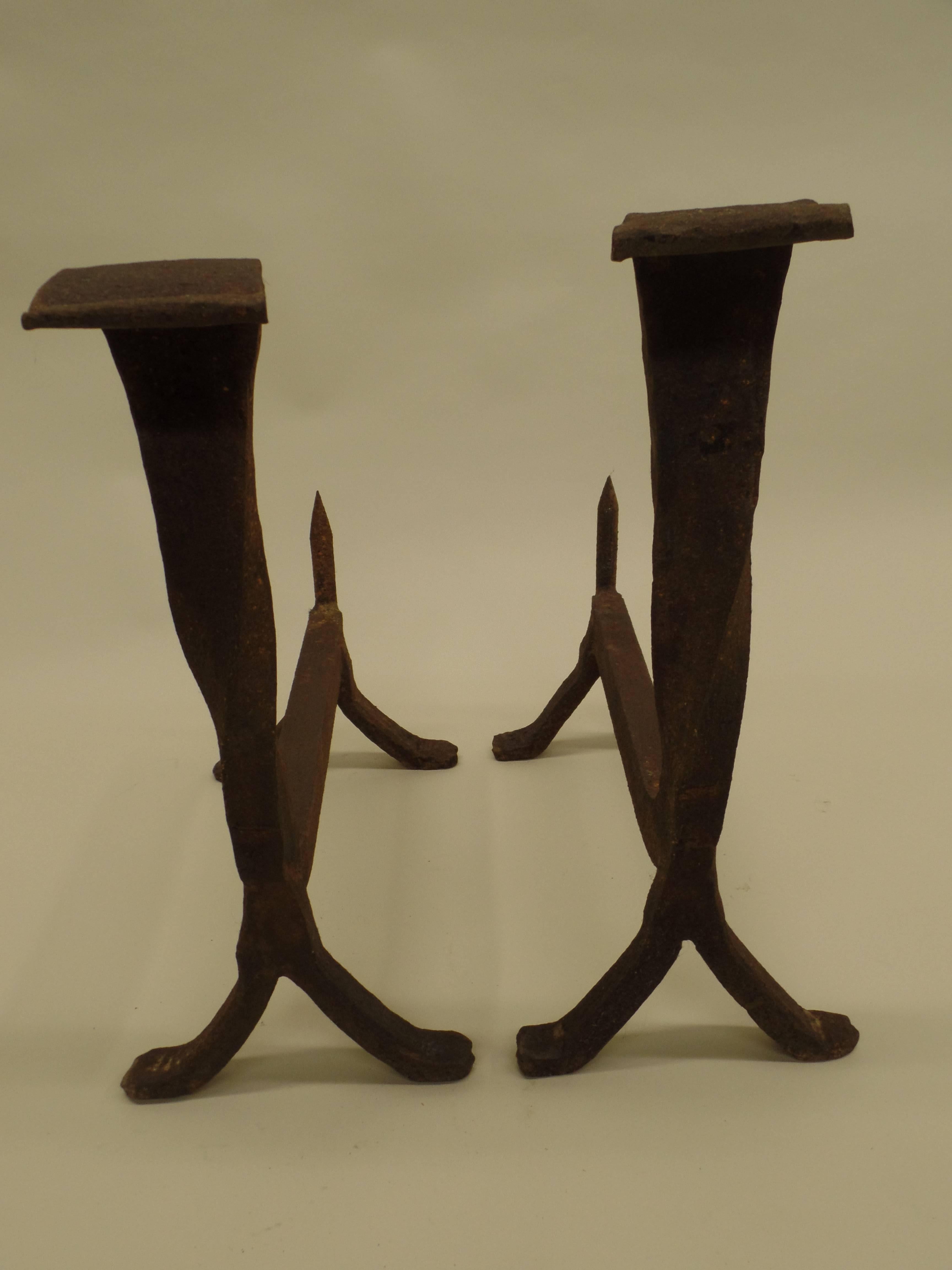 Pair of French Mid-Century andirons in hand-hammered Iron. The pieces reflect both Modern and French Art Deco design and the work of the great French ironworkers including Raymond Subes and Gilbert Poillerat.