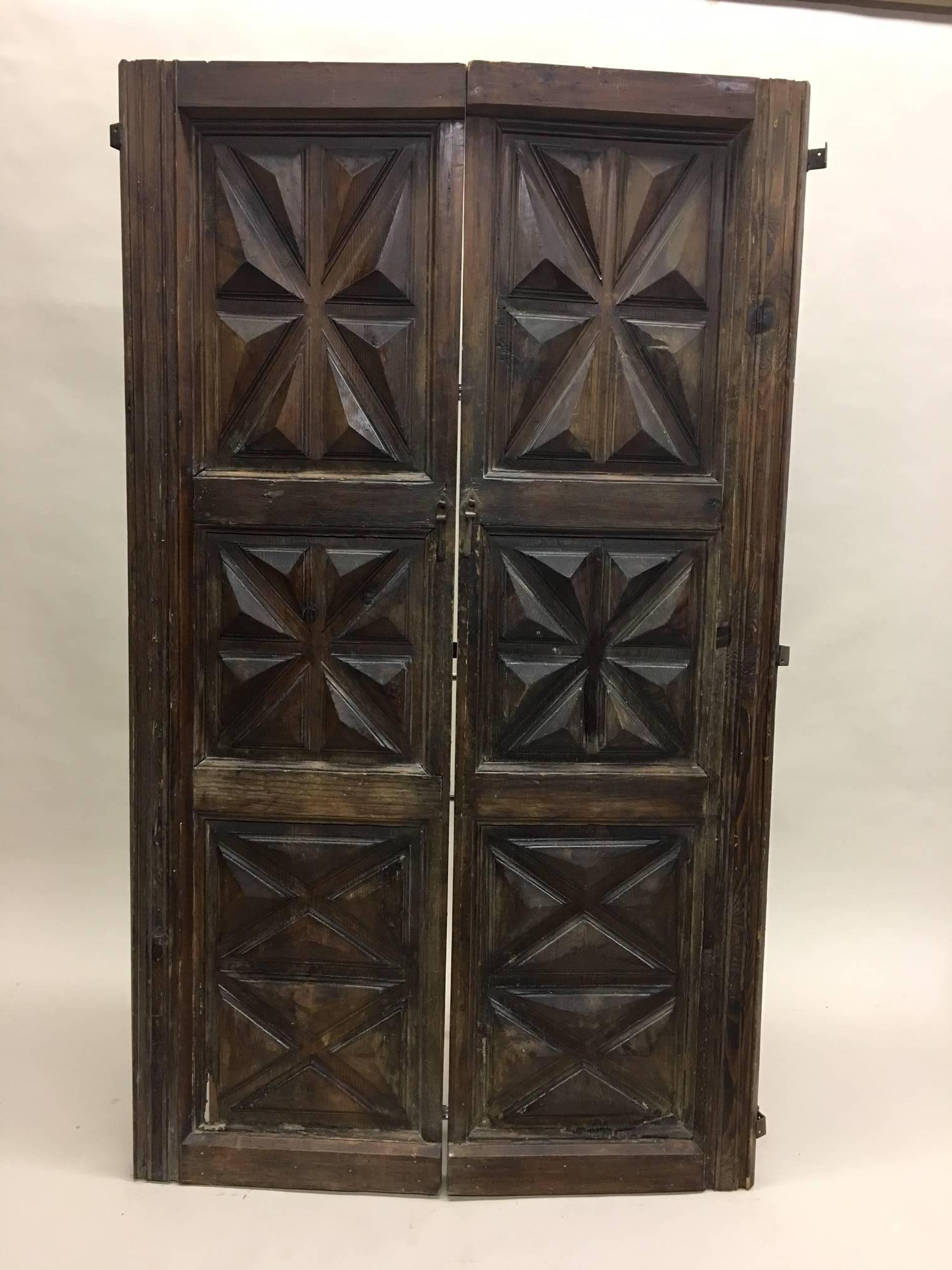 French 19th century set of hand-carved wood doors that can also function as a folding screen.

Authentic, charming wood doors with Classic diamond and lozenge patterns deeply carved into them. The doors can unite to form a folding screen.
