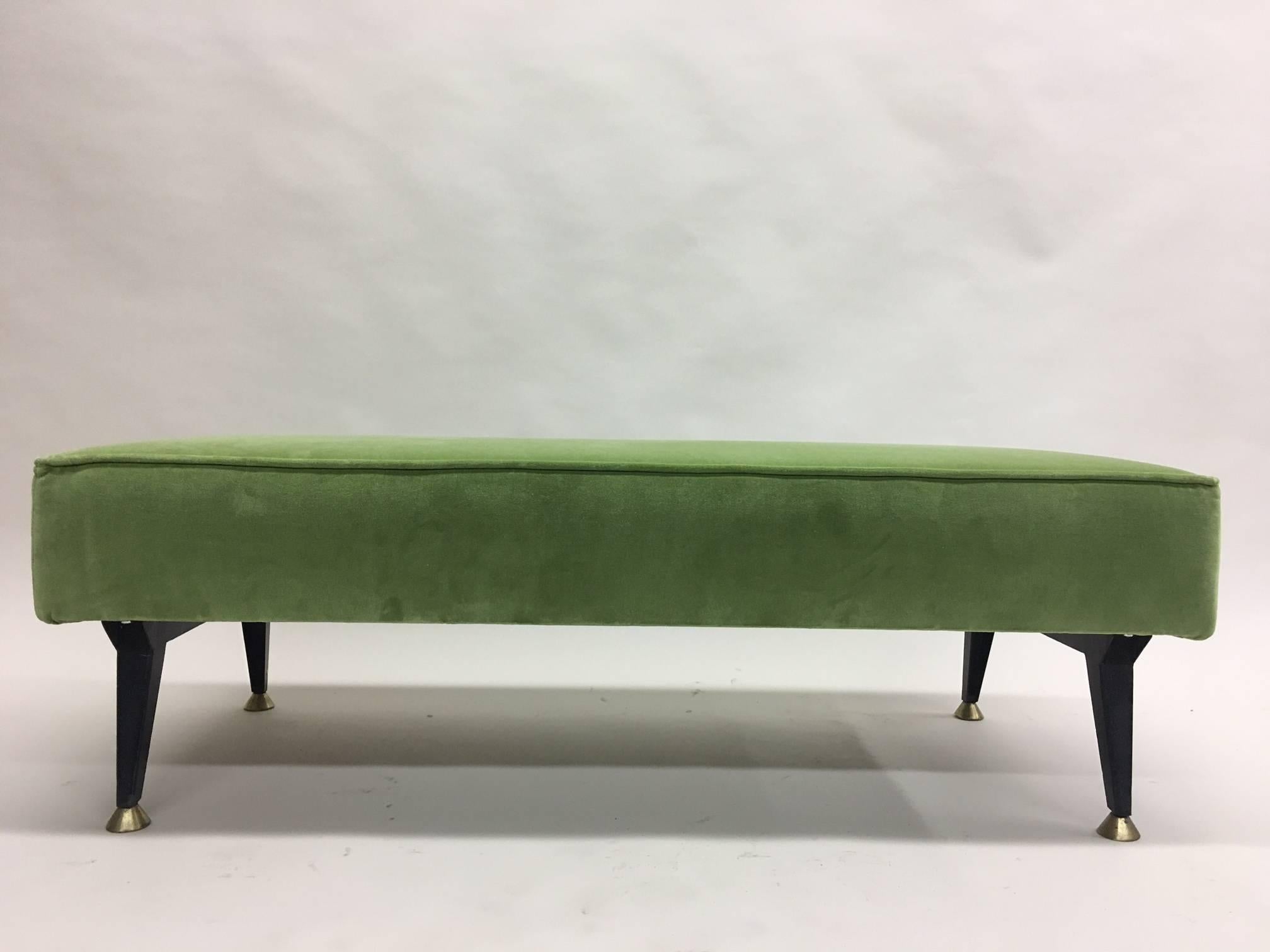 Elegant Italian Mid-Century Modern bench in the style of Osvaldo Borsani featuring four saber form and tapering black enameled metal legs ending in solid brass sabots. The piece is low to the ground, sleek and chic!

New velvet upholstery.