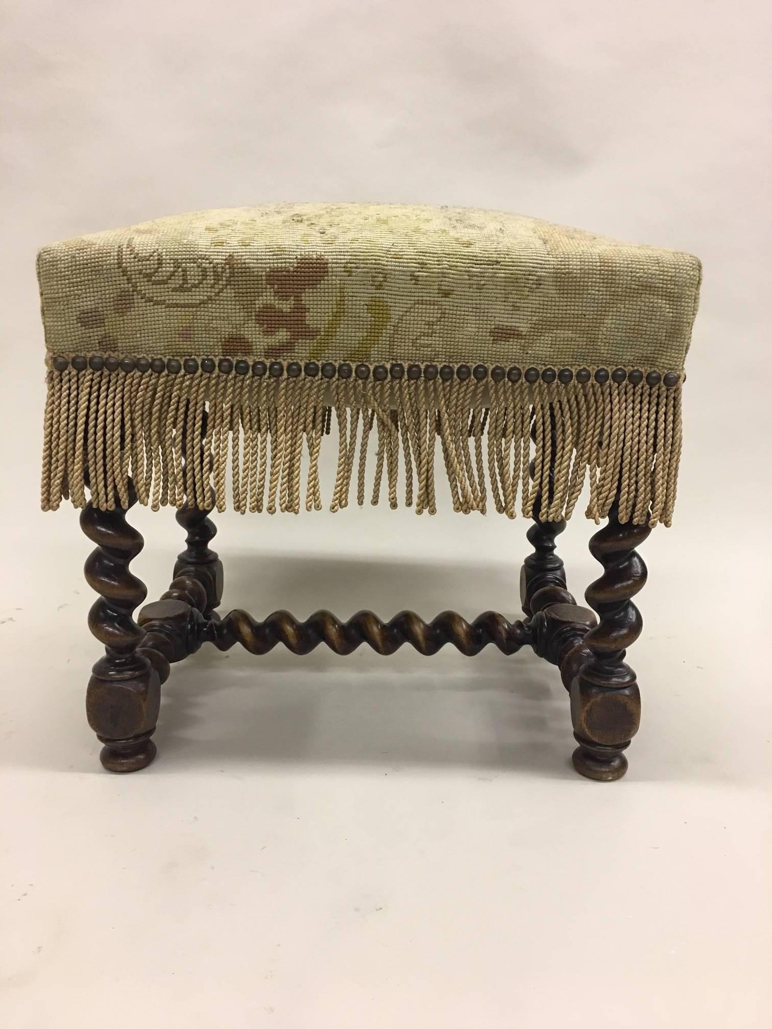 Elegant, timeless pair of French hand-carved benches, stools or ottomans in the style of Louis XIII. The pieces are carved in a barley twist pattern. The seats are in needlepoint but can be changed to suit taste as the pieces can function in a hip