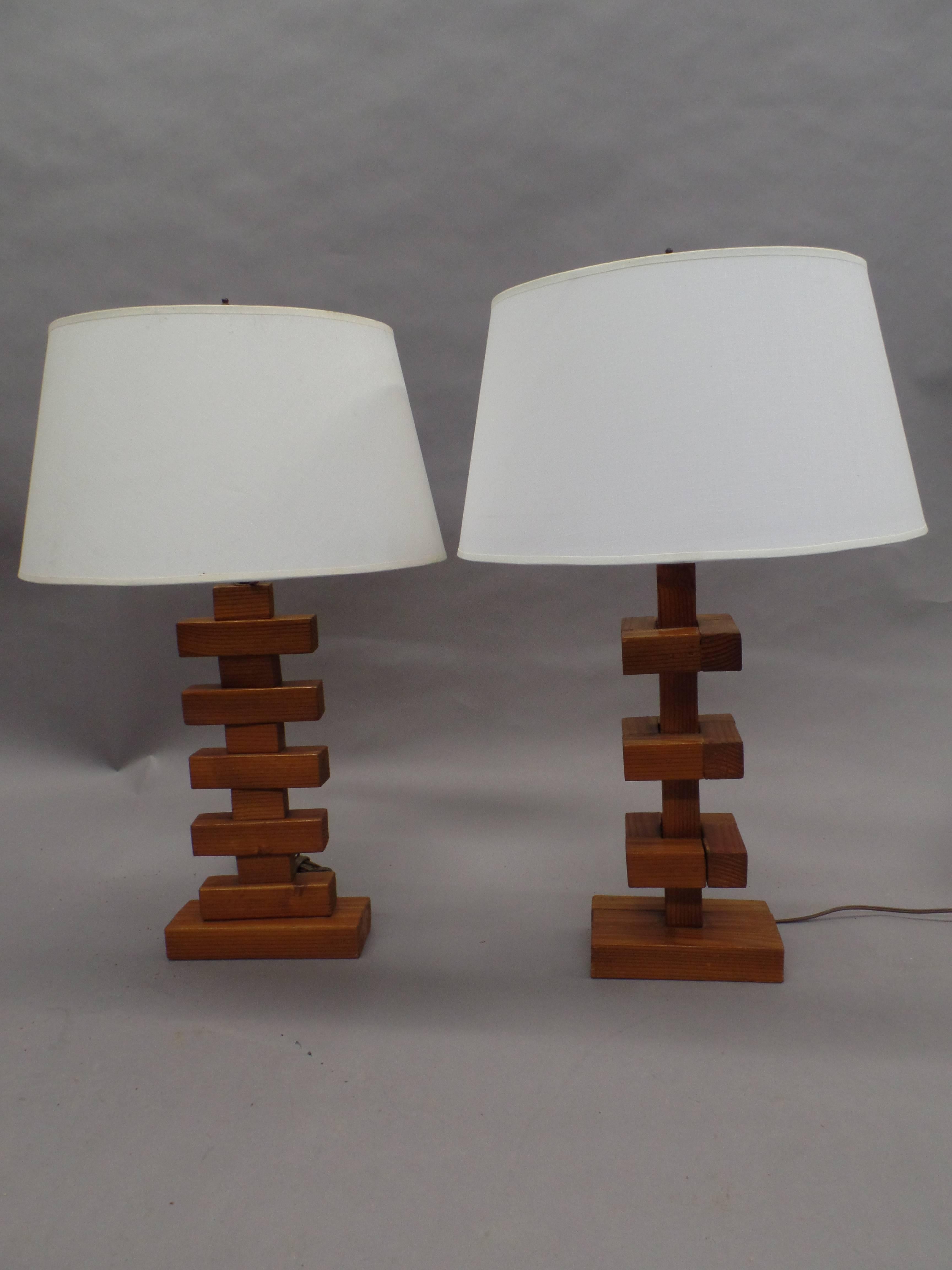 Seltenes Paar handgefertigter Holz-Tischlampen aus der Mitte des Jahrhunderts mit skulpturalen Sockeln, die konstruktivistische und kubistische Prinzipien verwenden. Jede Leuchte ist anders und ergänzt sich gegenseitig. Beide setzen auf mehrere sich