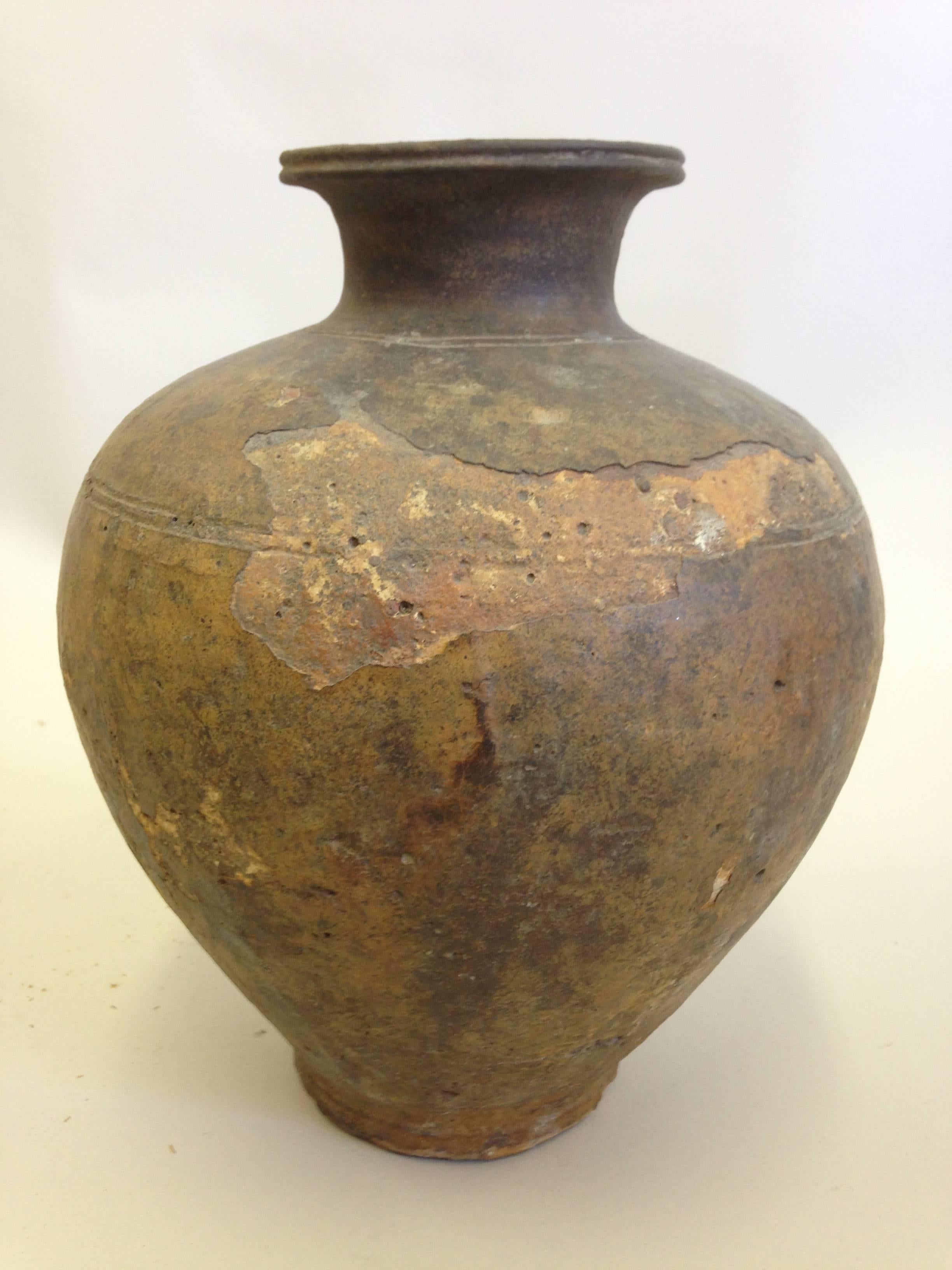 Large ancient Khmer Urn or Vase in a sober, Classic form. The piece has varied and beautiful coloration due to the effect of time, humidity and weather on the clay structure. 

Khmer pieces highlight modern and traditional environments because of