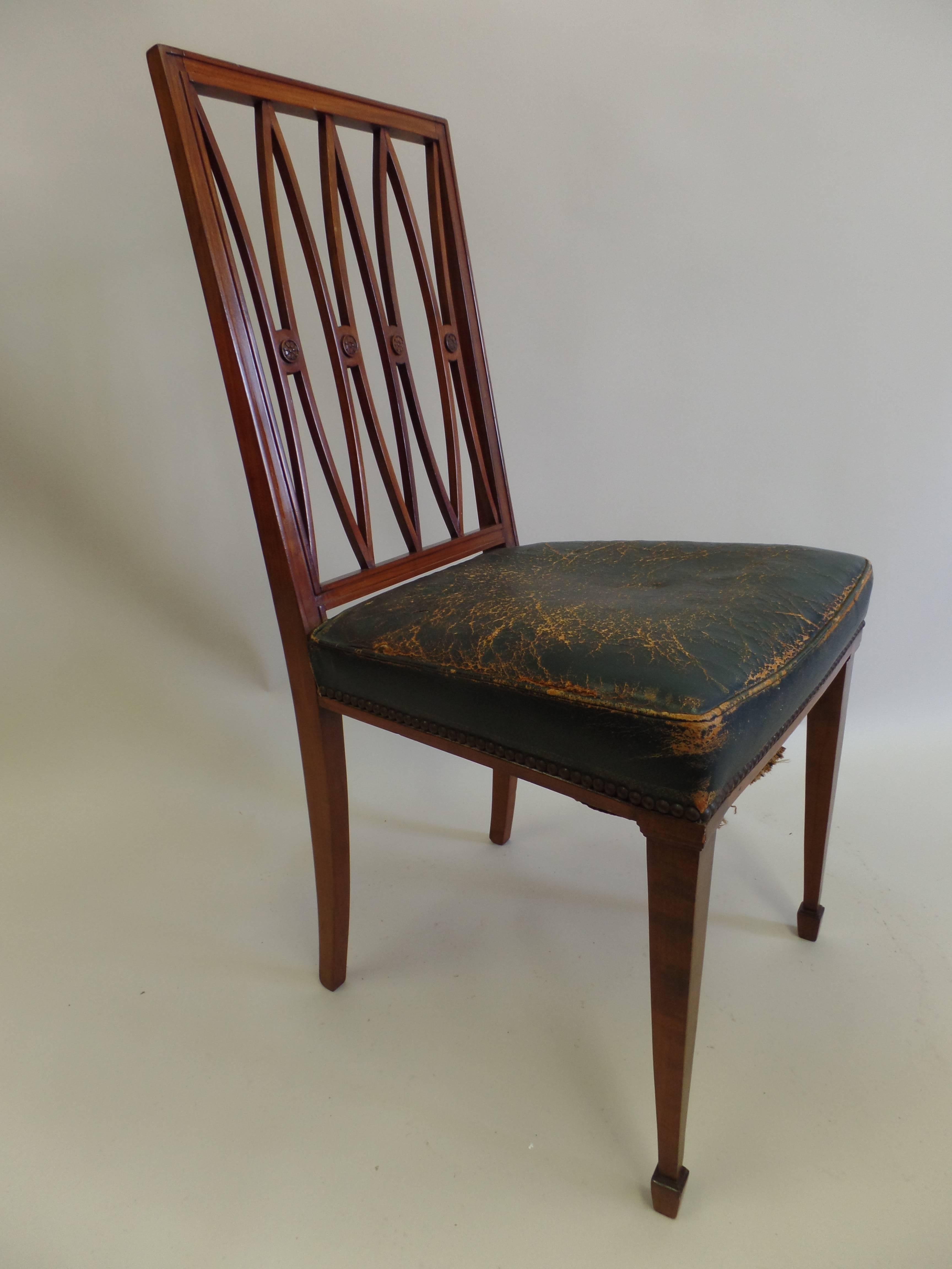 Pair of refined French modern neoclassical desk chairs / side chairs attributed to Andre Arbus with elegant tapered front legs ending in blocked finial feet balanced with rear saber legs, supporting a leather seat and cut-out backrest in the form of