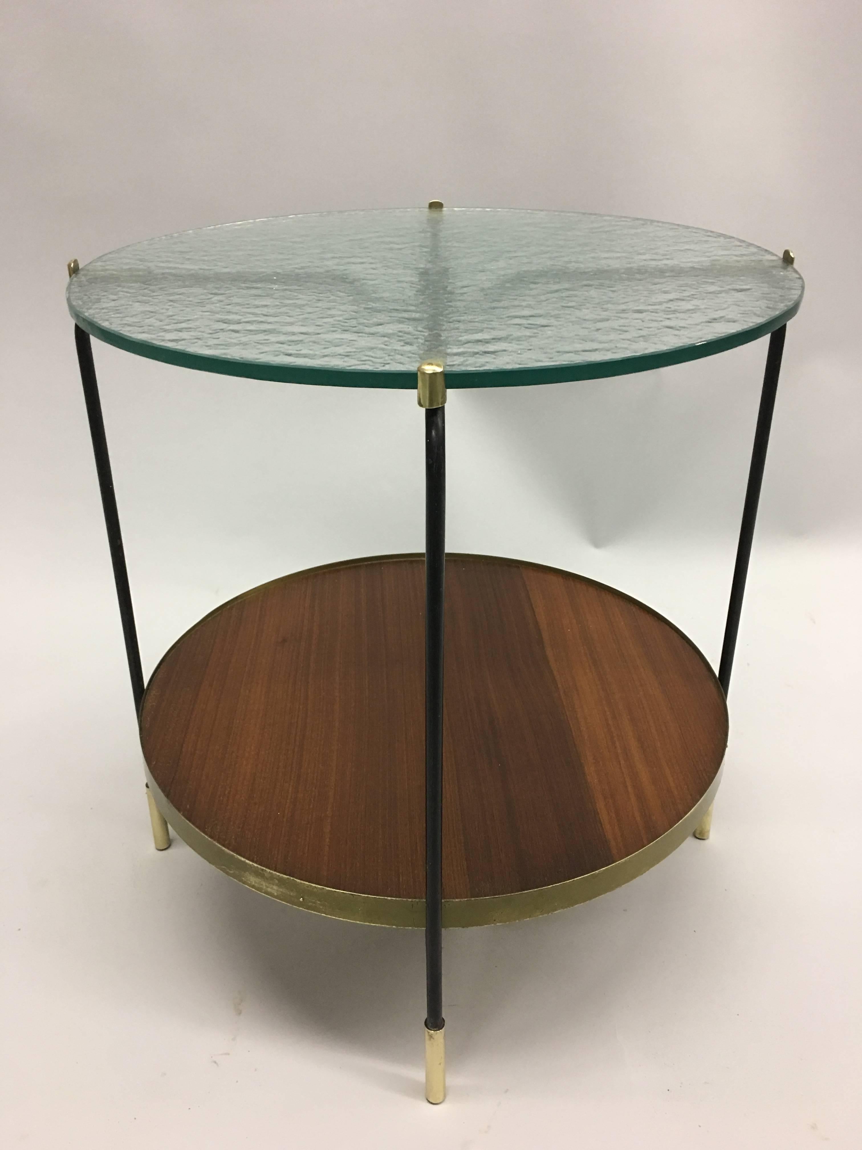 Elegant Italian Mid-Century Modern double level drinks table, side, end, cocktail table or gueridon. 

The piece is composed of a sensitive combination of materials including a black enameled steel frame with brass feet and details, a sand cast