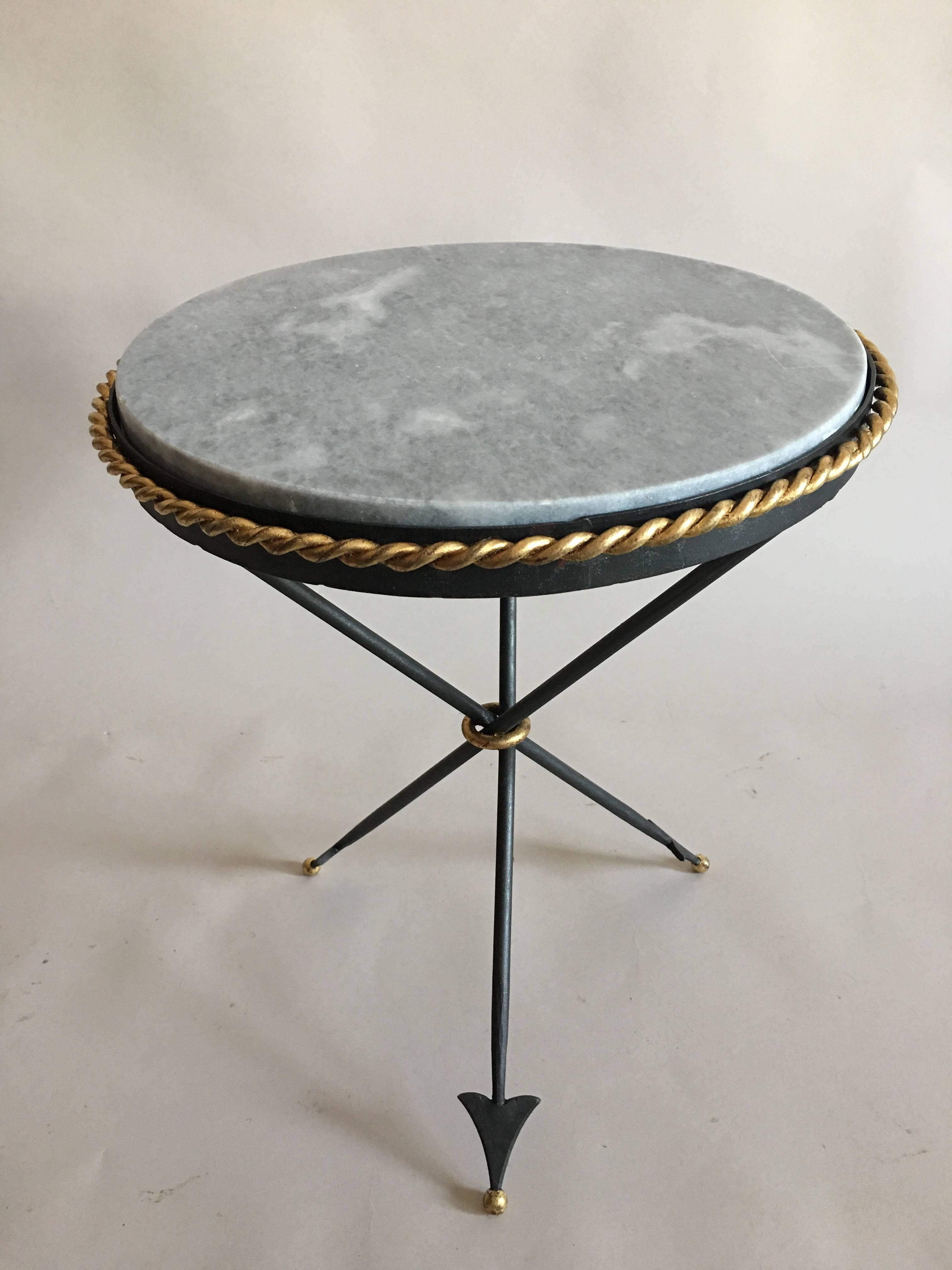 French Modern Neoclassical gueridons, side tables, end tables or nightstands in the style of Gilbert Poillerat. The pieces are composed of hand forged wrought iron, with elegant gilt roping, marble top is supported by three legs in the form of