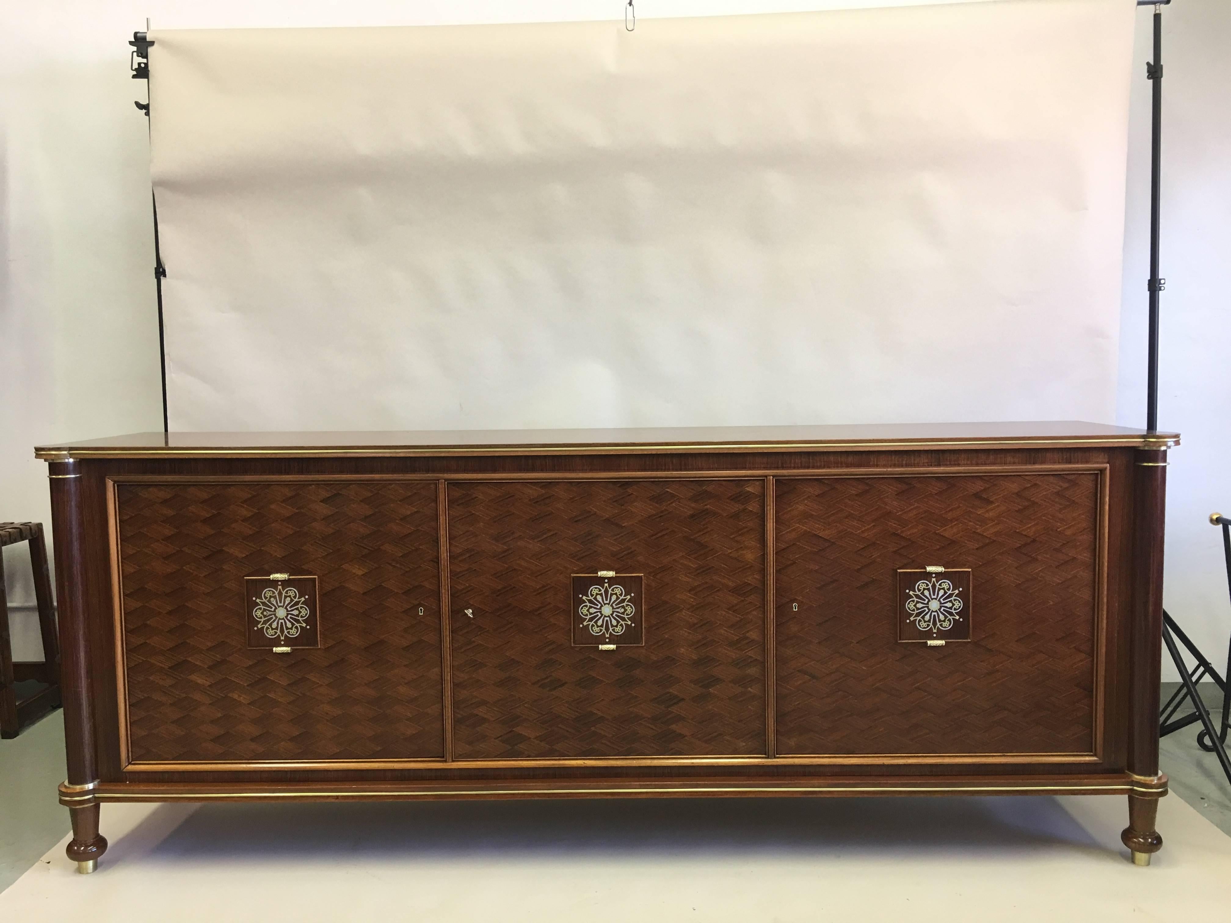 Large, Elegant French Art Deco Mahogany sideboard, buffet or credenza by Jules Leleu in the modern neoclassical spirit with exquisite tin and brass marquetry inlays. 

The cabinet features Herringbone mahogany pattern on three doors with intricate