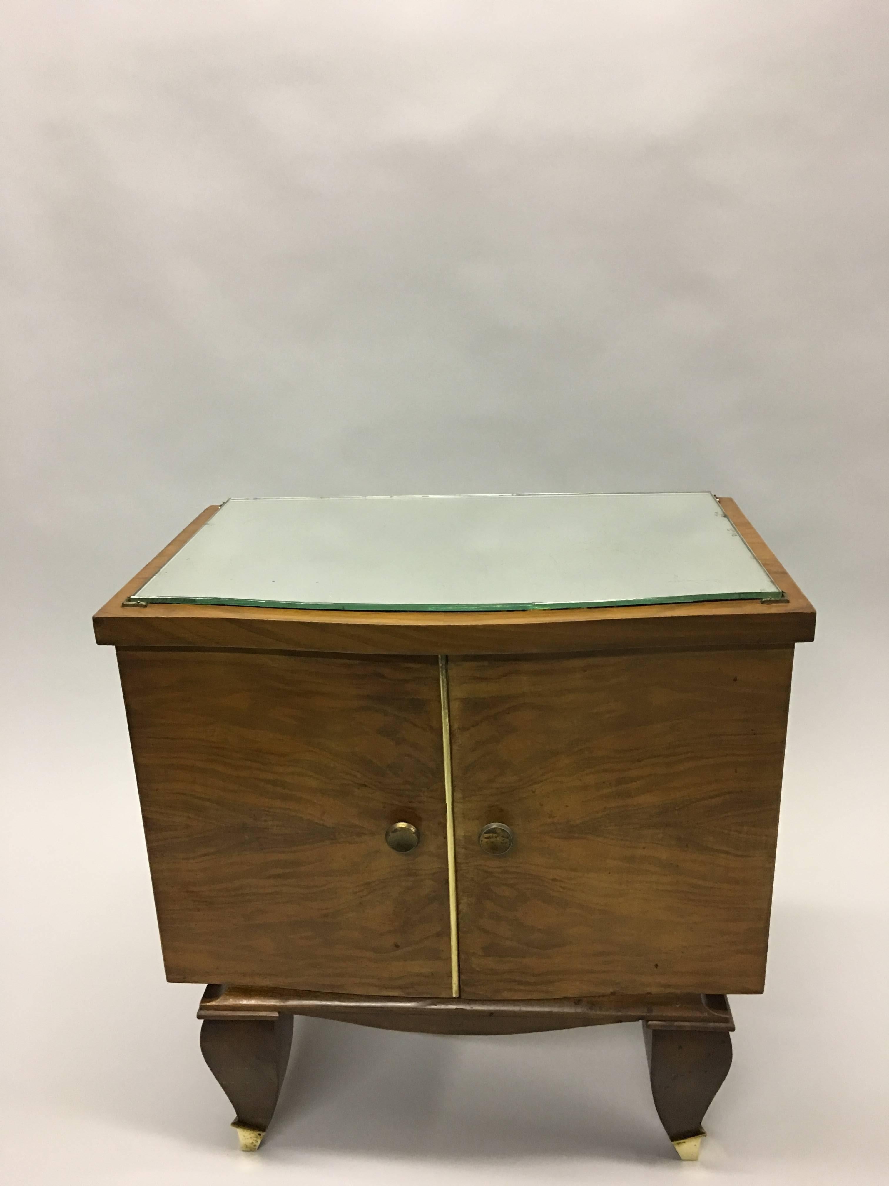 Elegant pair of French Mid-Century Modern neoclassical side tables/nightstands attributed to Rene Prou, circa 1940. 

The pieces are composed of veneered fruitwood and cantilevered above the 4 legs. The front feet have brass sabots. A mirror top