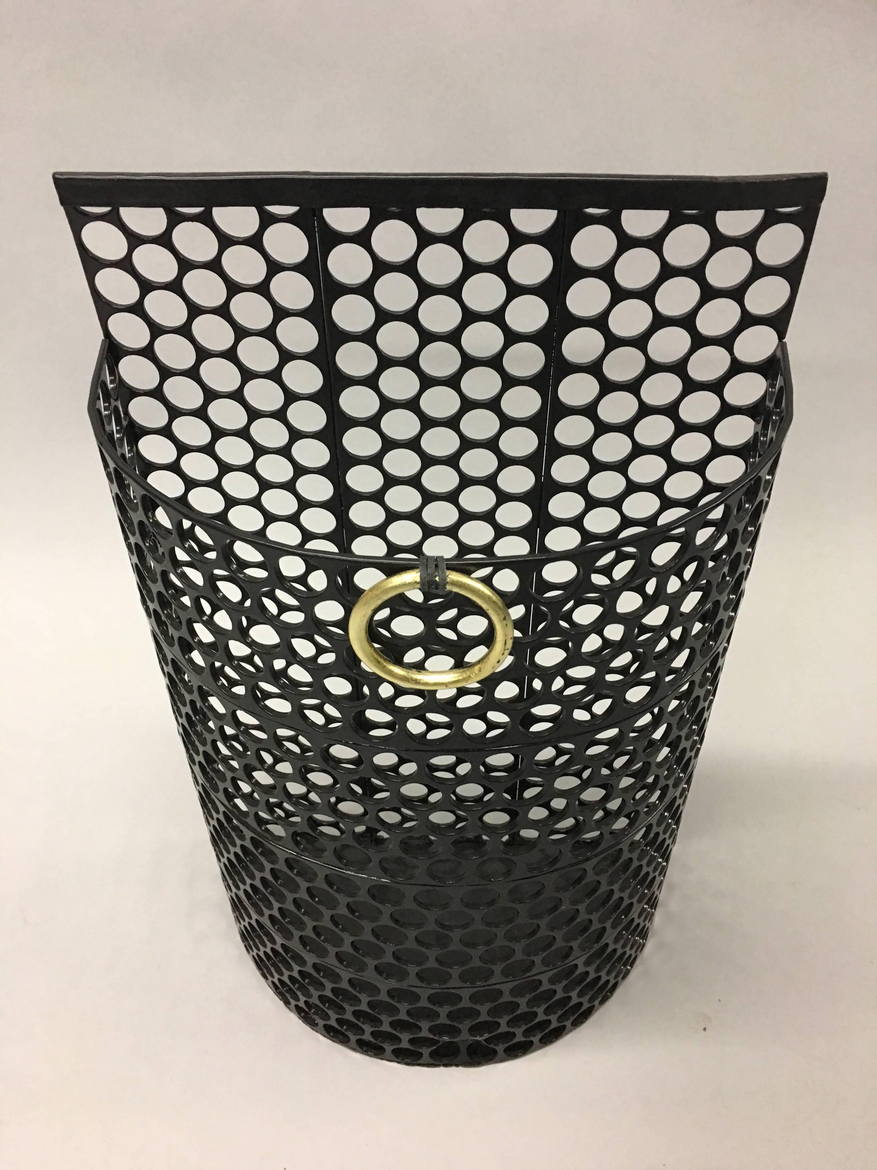 French Mid-Century Modern umbrella stand or trash / wastebasket composed of black enameled perforated iron / steel adorned with an elegant gilt iron ring pull in the style of Jacques Adnet, circa 1950.

References: Industrial, Neoclassical, Jean