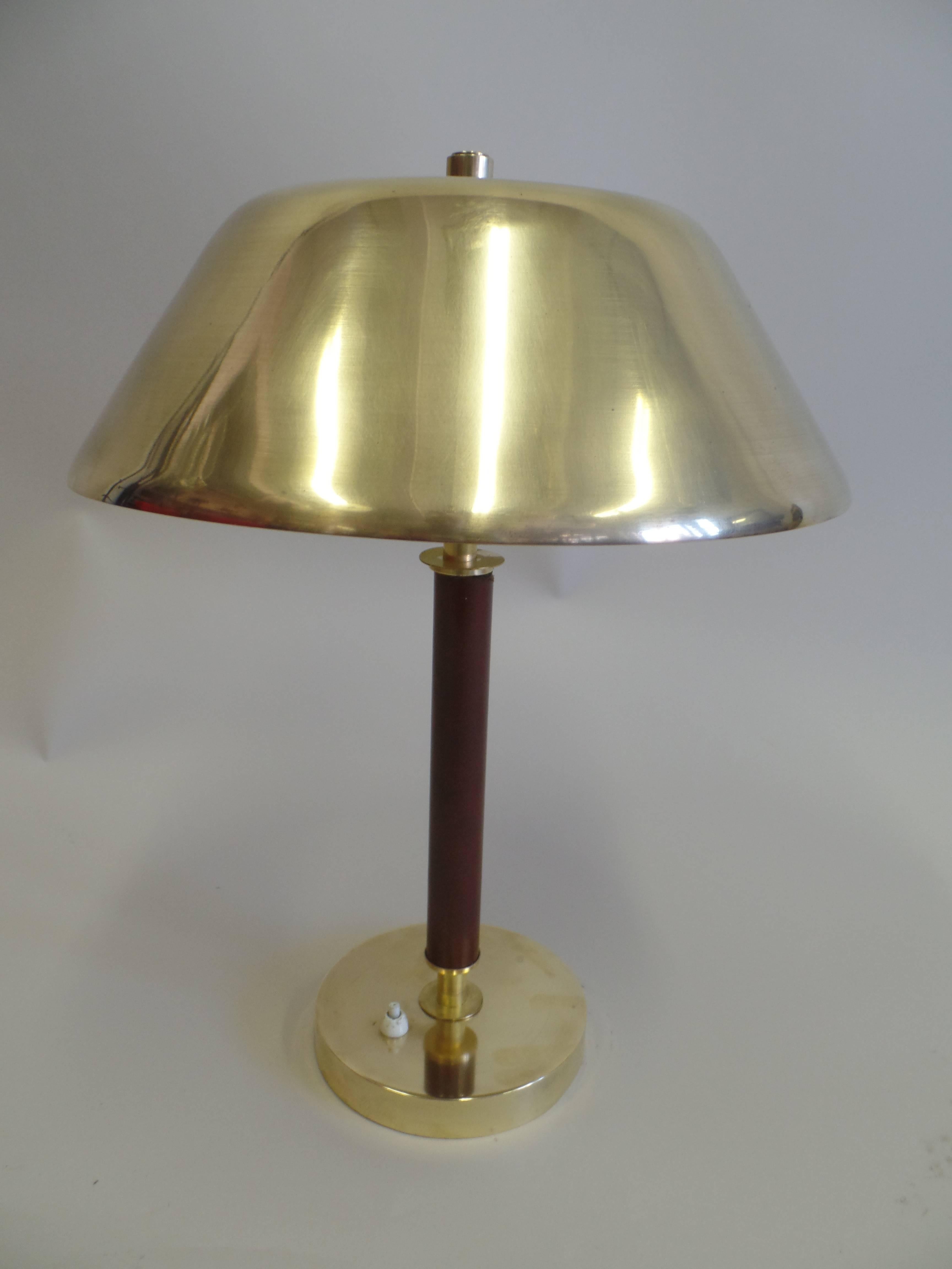 Elegant modern brass and leather desk or table lamp attributed to Jacques Adnet with a dark brown leather stem, solid brass base and shade.