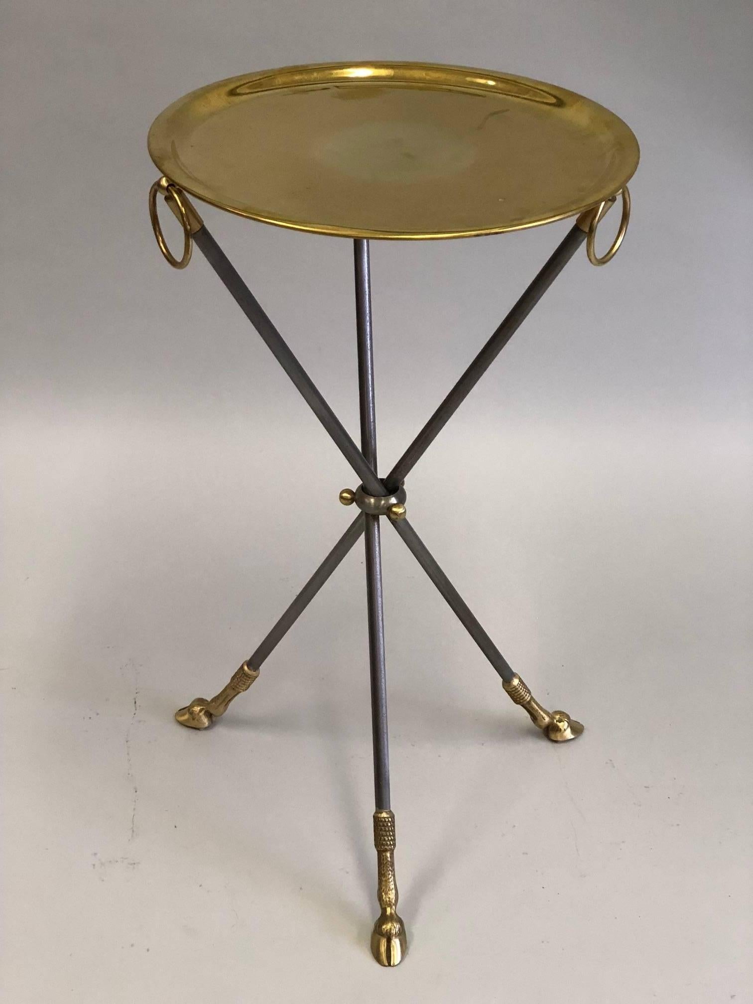 Elegant, timeless pair of French midcentury gueridon or end tables in the modern neoclassical spirit by Maison Baguès.

The pieces are composed of a tripod base resting on three hoofed solid brass feet. Which supports three steel legs that unite