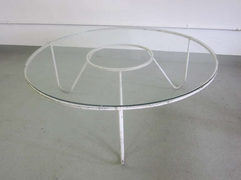 An elegant and timeless, stunningly pure design statement: A French Mid-Century Modern coffee table in the style of Mathieu Mategot in hand-wrought iron that has been enameled white. The piece is round, in a circular form with round, concentric