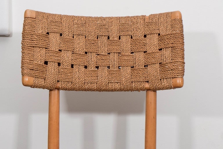 Pair of vintage American chairs with raffia woven seats and back. The frames stands in its original finish and can be customized on request. Beautifully carved with great proportions.