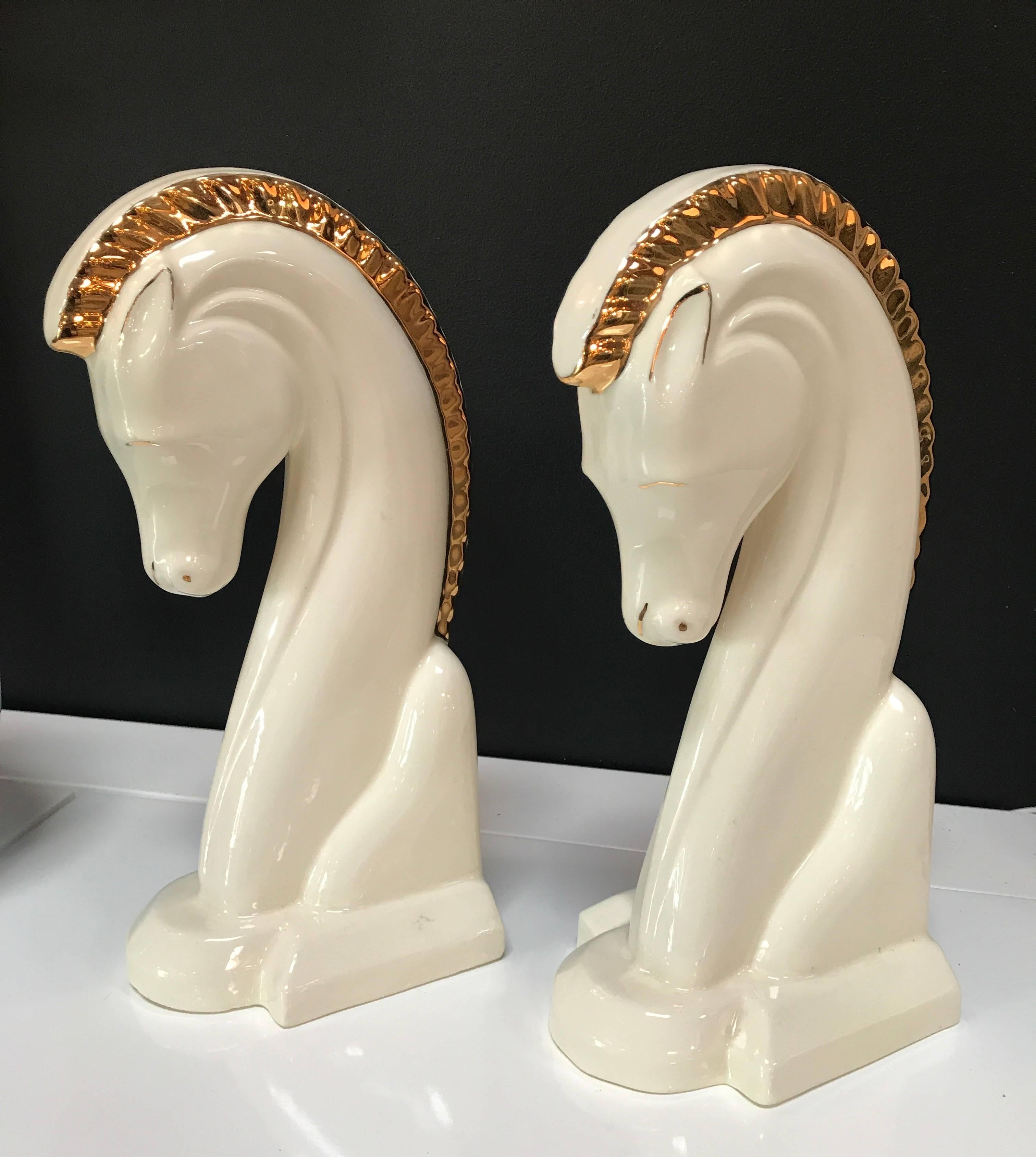 Two ceramic horse head bookends in cream and rich gold, signed by the artist.