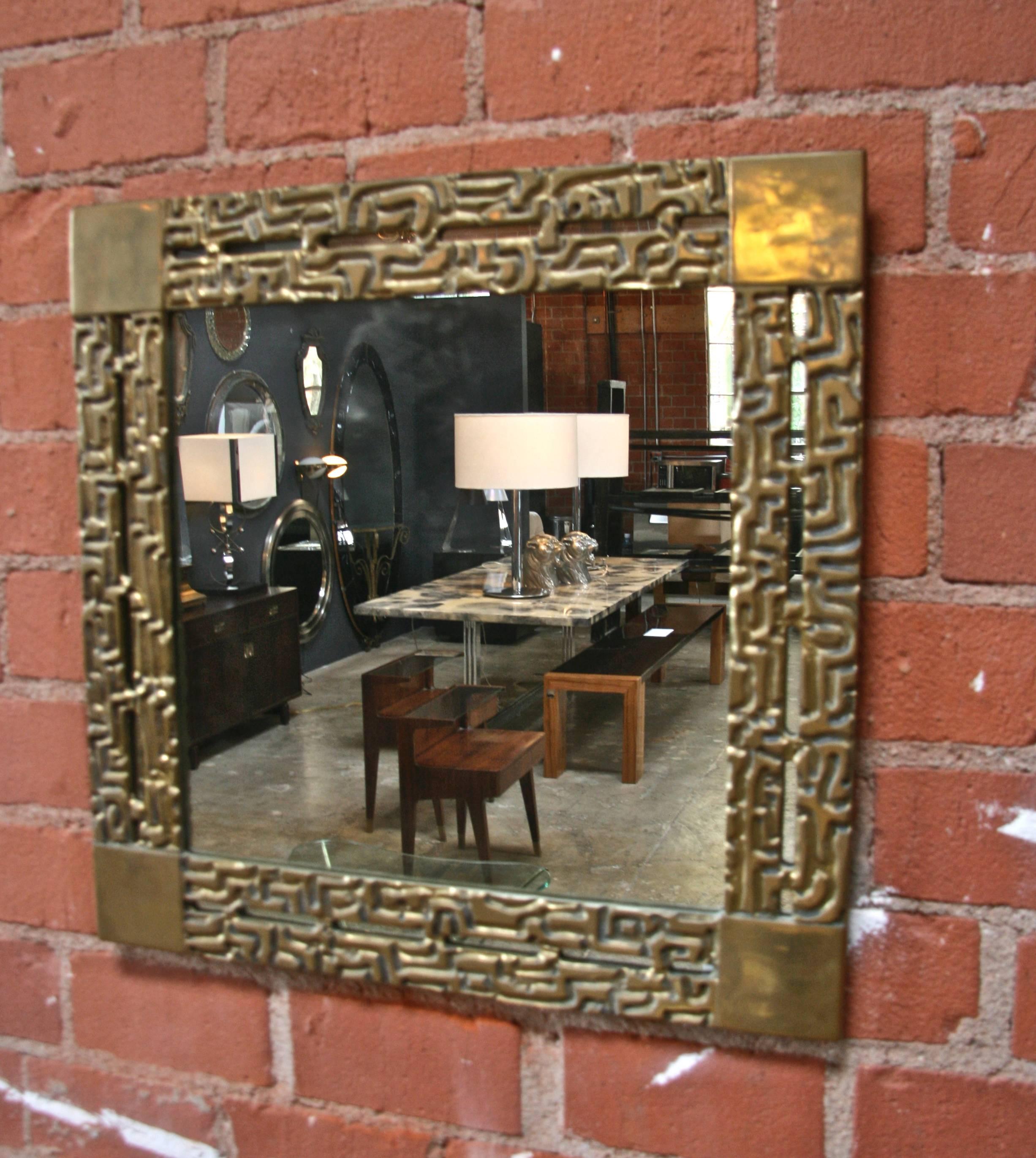 A square wall mirror featuring a frame in cast bronze and a clear center mirror. Luciano Frigerio, Italy, 1966.
