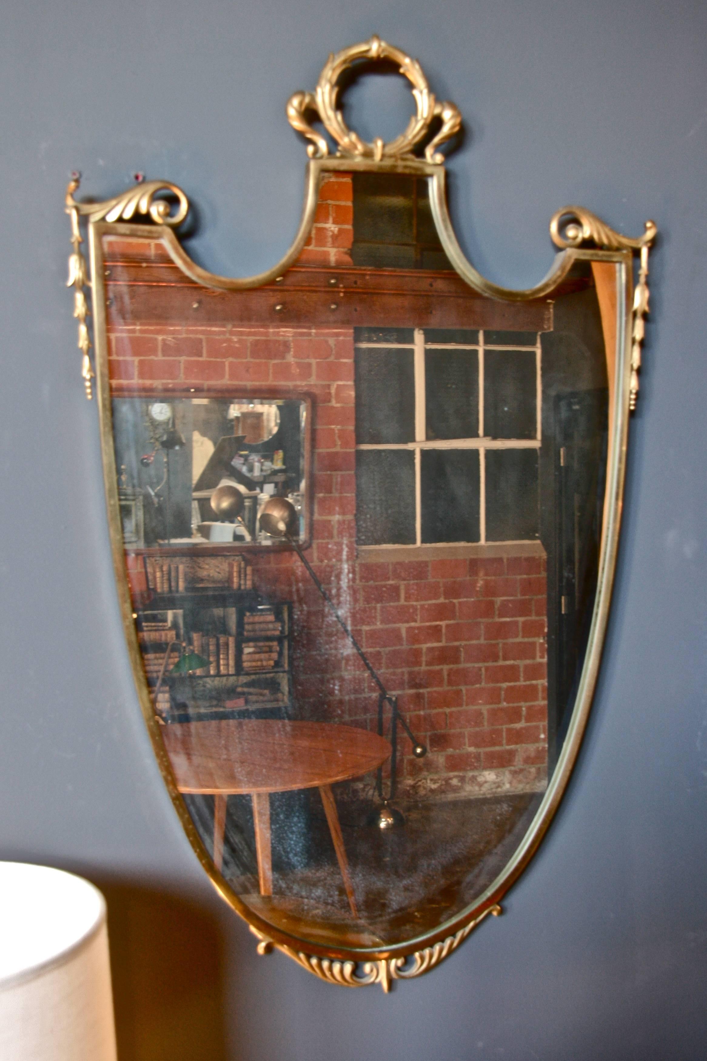 Italian 1960s brass shield shaped framed mirror.