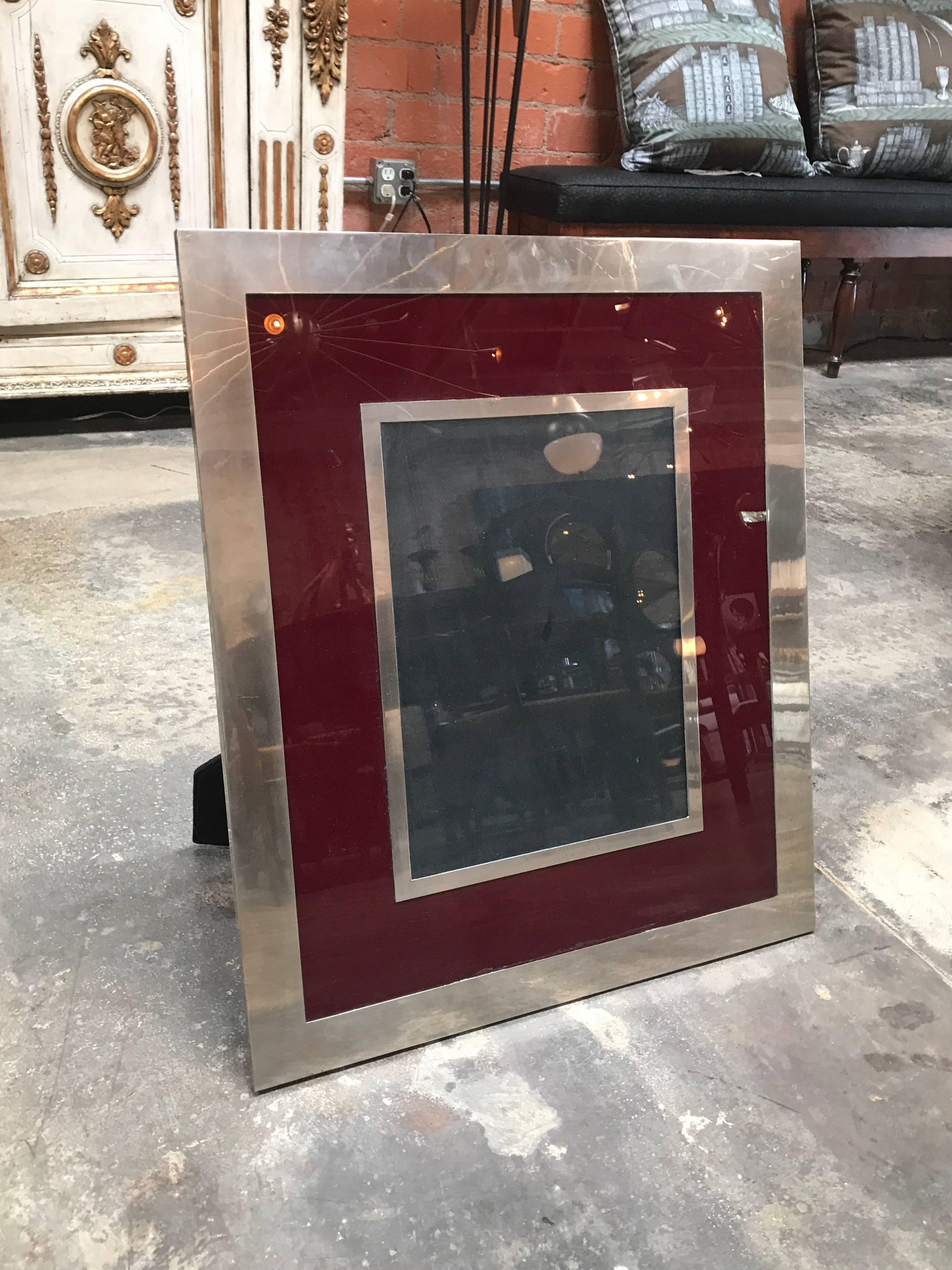 A chic 1970s modern Italian rectangular picture frame. Silver and burgundy color
easel backing in black velvet.
