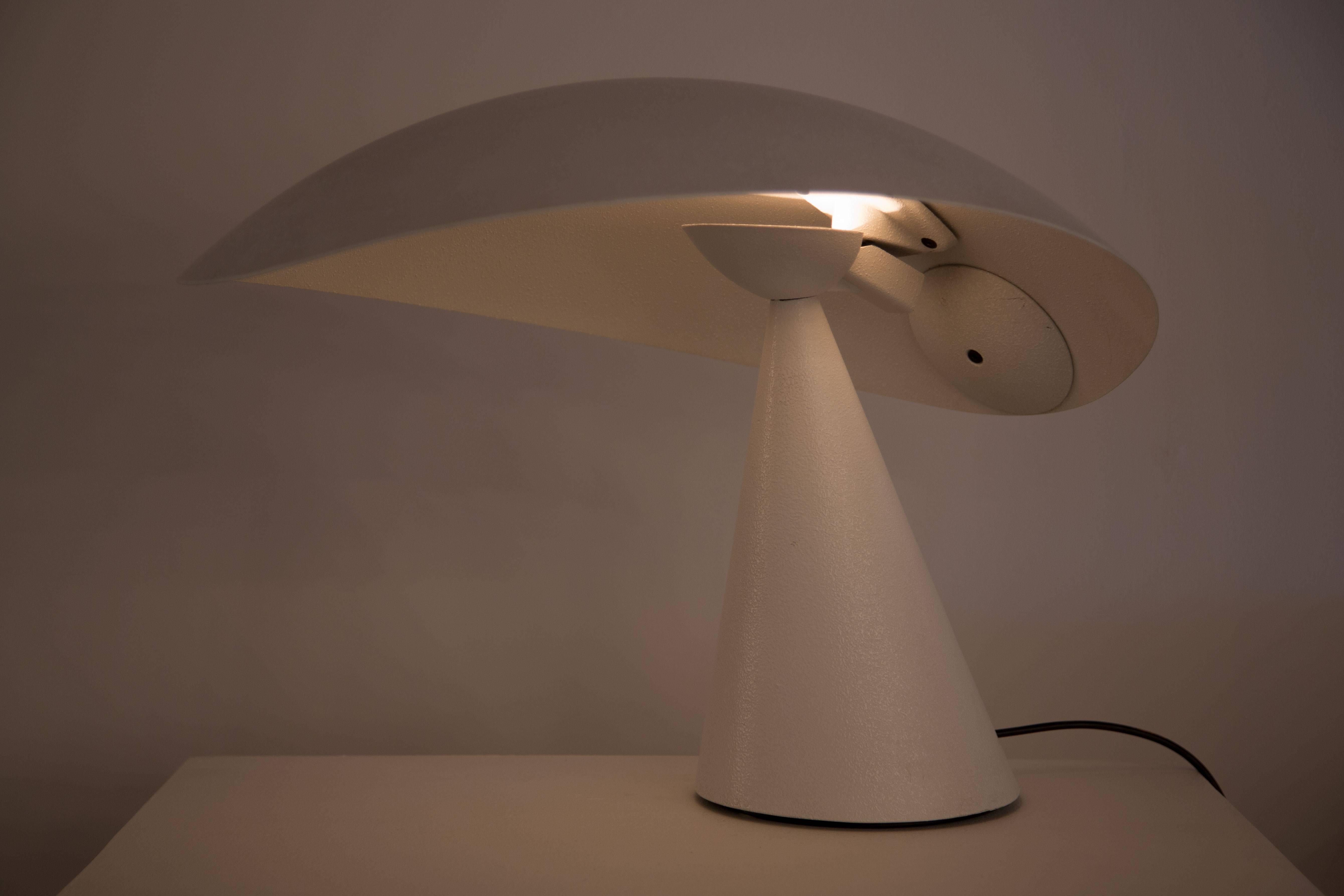 Table lamp with white enameled metal structure and large curved articulating shade retains original label. Dimmer switch with two settings.